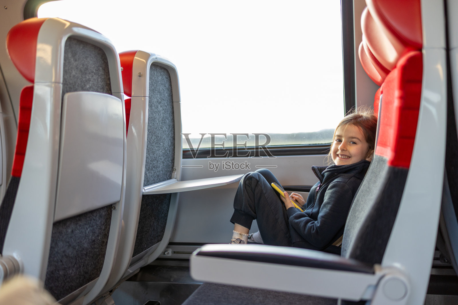 可爱的小女孩在火车上打电话照片摄影图片