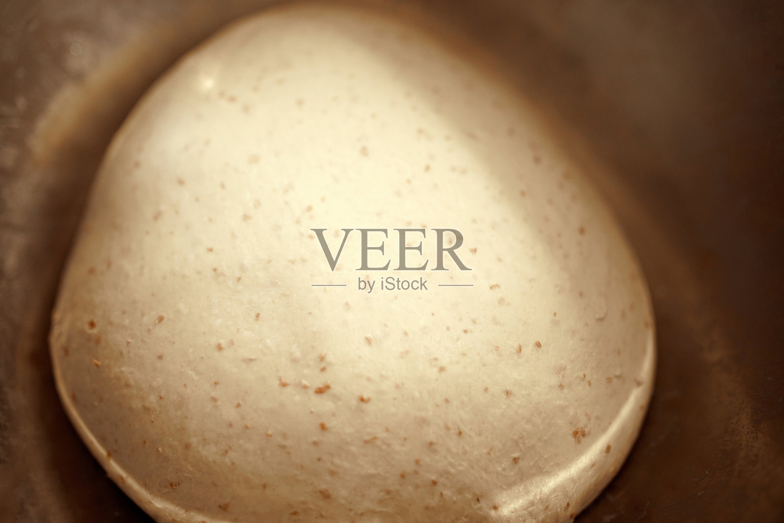 特写镜头的面团球看起来光滑和有弹性，由环保成分制成的不锈钢碗照片摄影图片