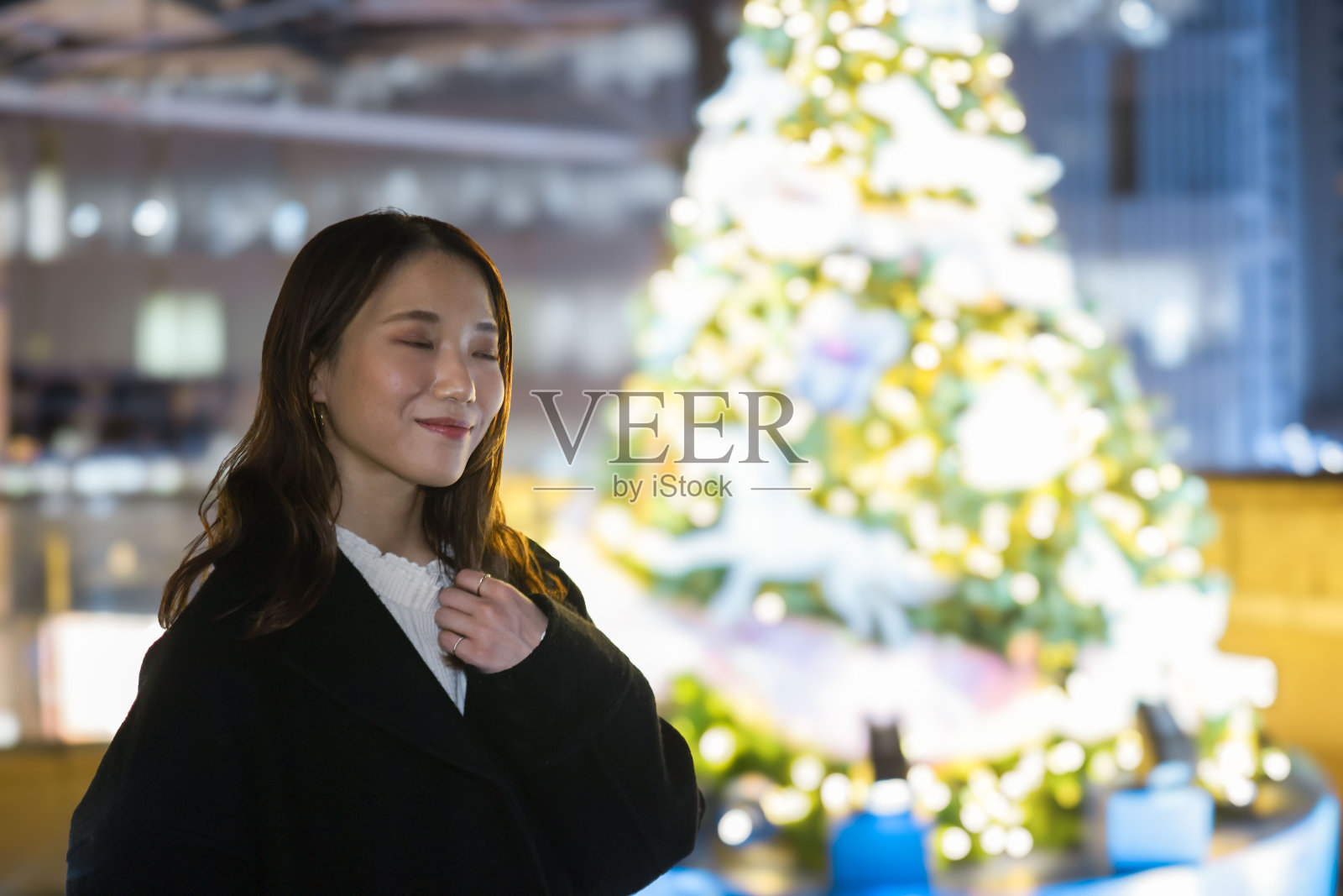 穿着圣诞彩灯的漂亮姑娘照片摄影图片