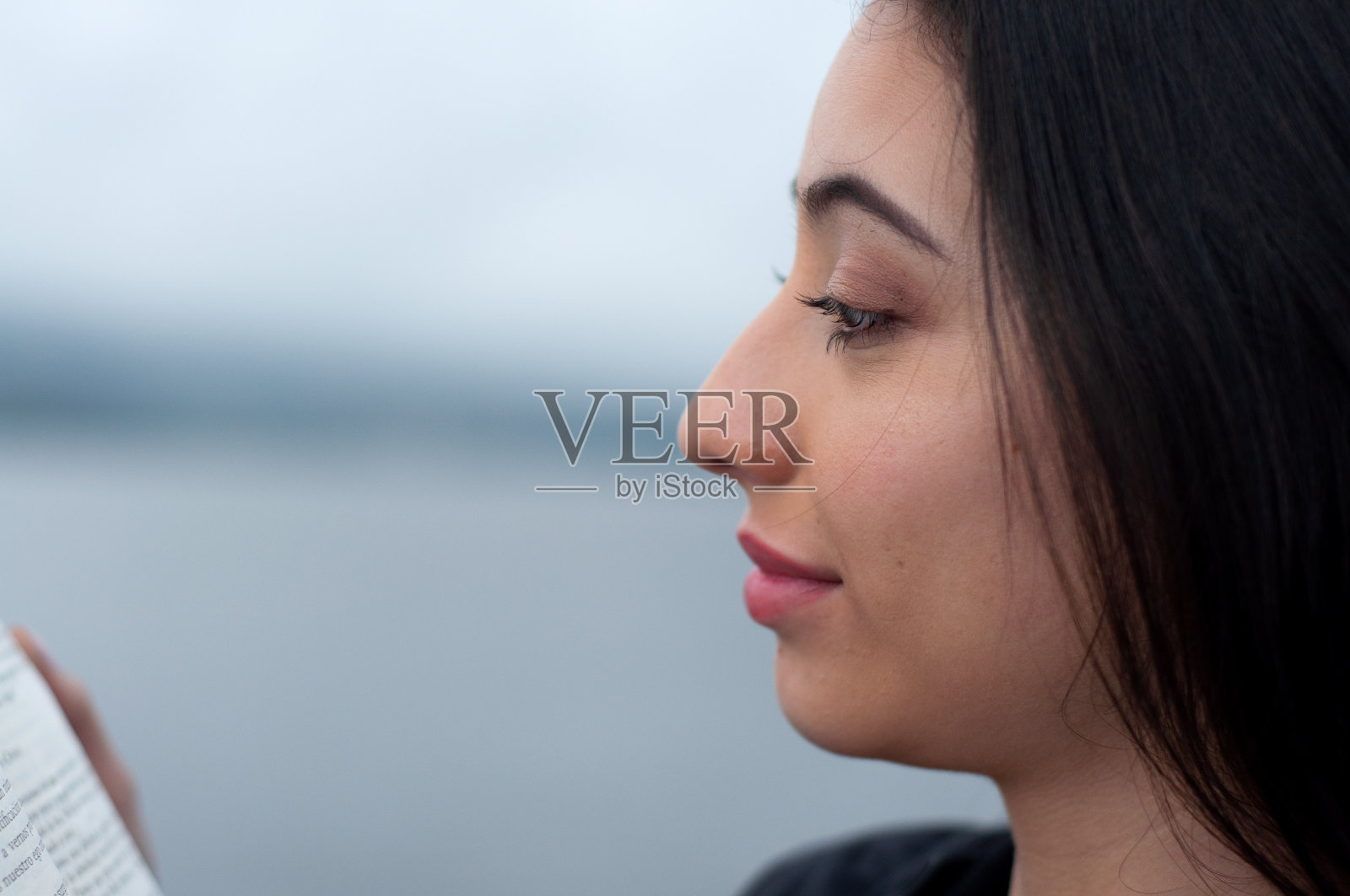 一个委内瑞拉女孩在湖边看书的特写广告空间。书的一天照片摄影图片