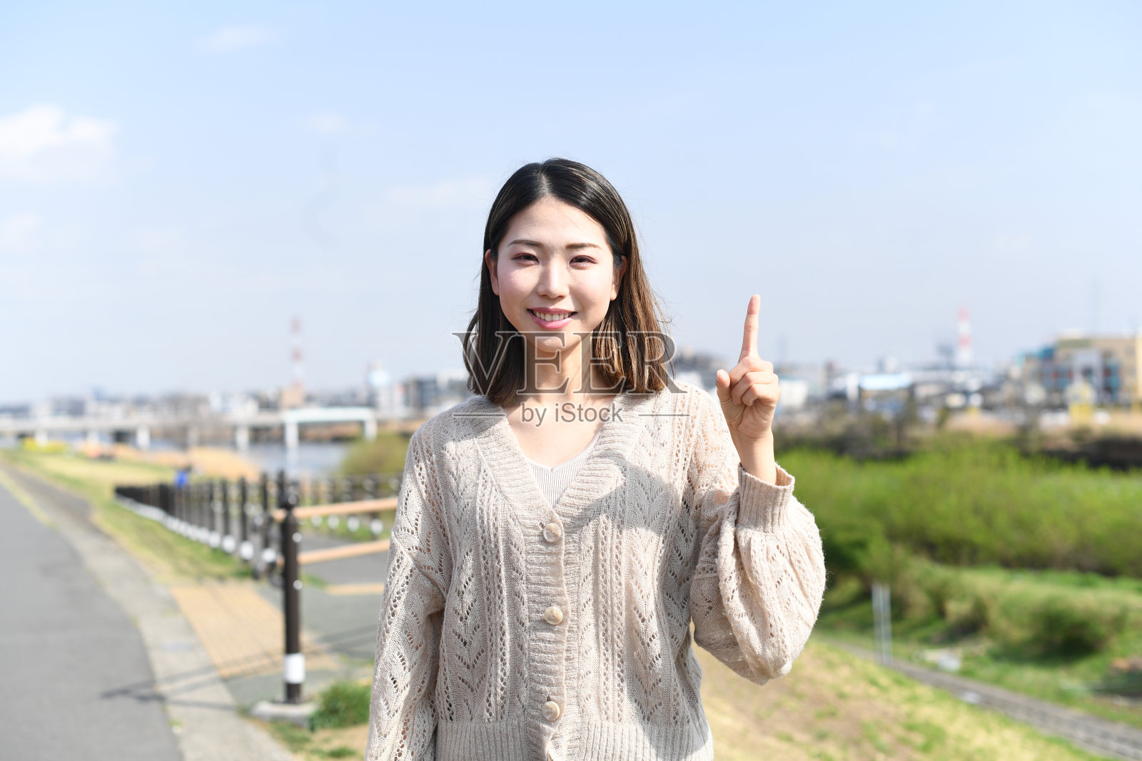 穿着休闲服的亚洲年轻女子在户外挥舞着食指照片摄影图片