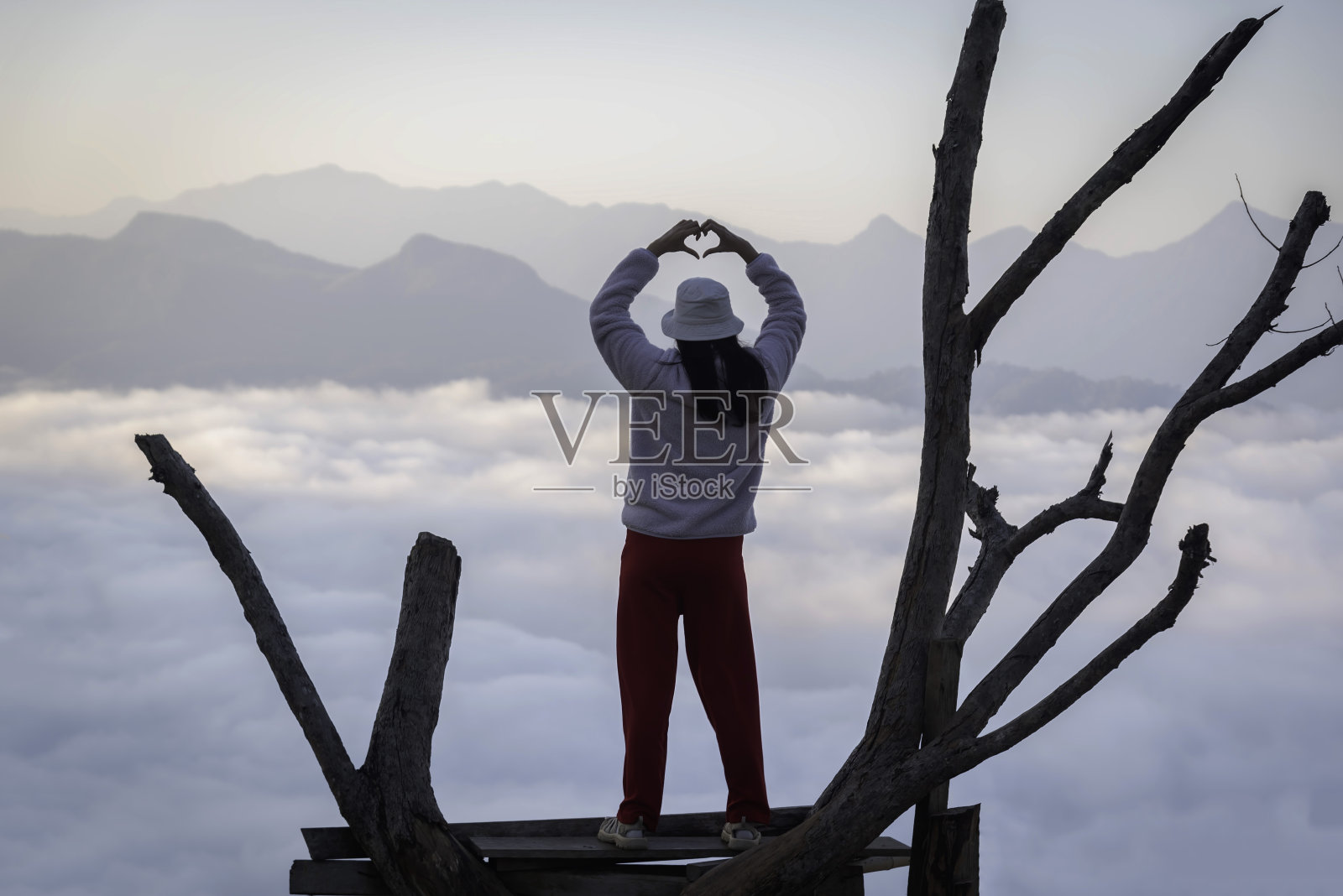 年轻的女旅行者早晨在山上看日出和雾海，旅行的生活方式概念照片摄影图片