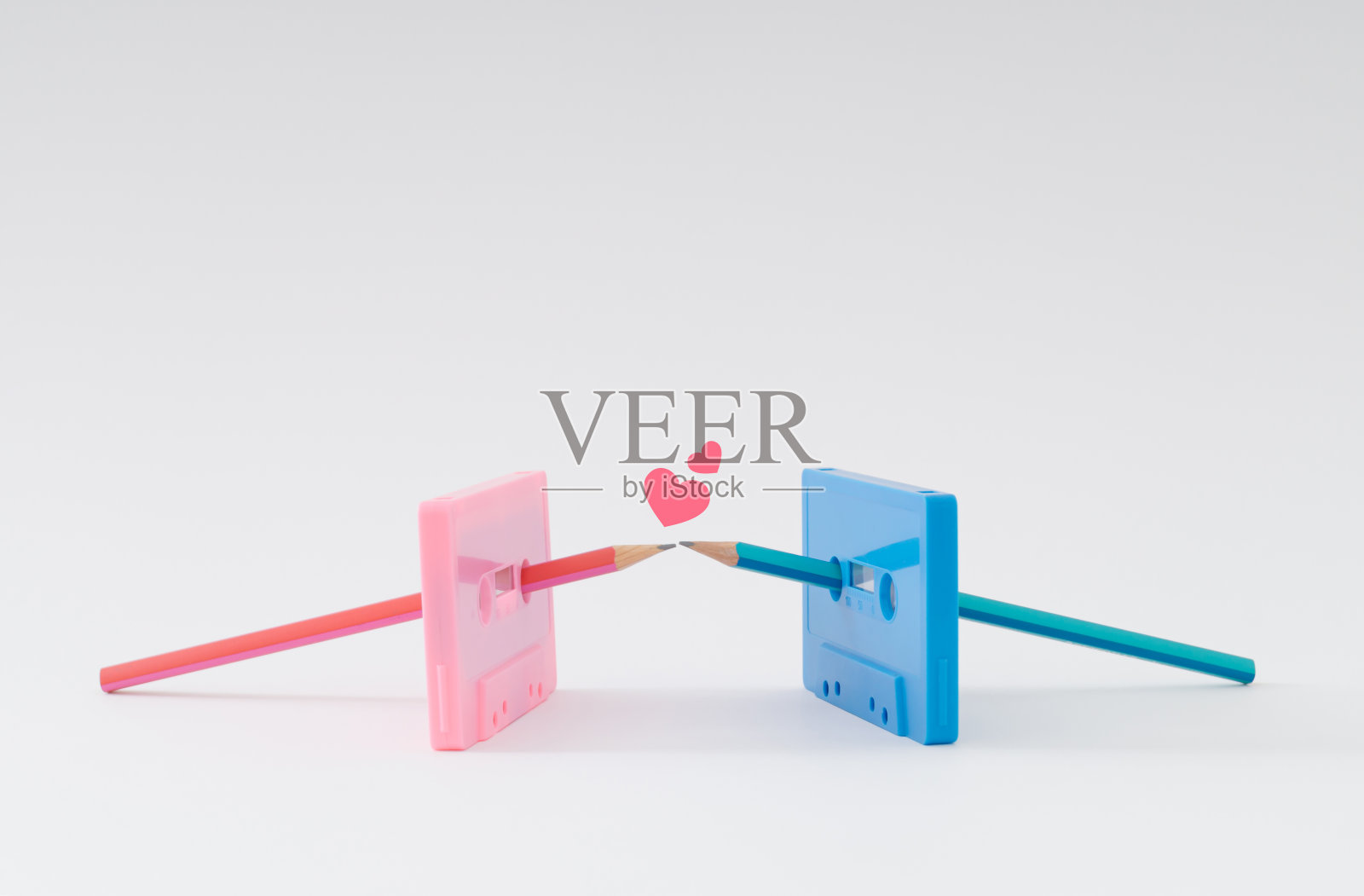 你是我盒式磁带上的铅笔。旧的粉红色和蓝色的录音带和铅笔在白色的背景上接吻。最小爱的概念。创意盒式磁带的想法。复古爱审美。复古的怀旧。照片摄影图片