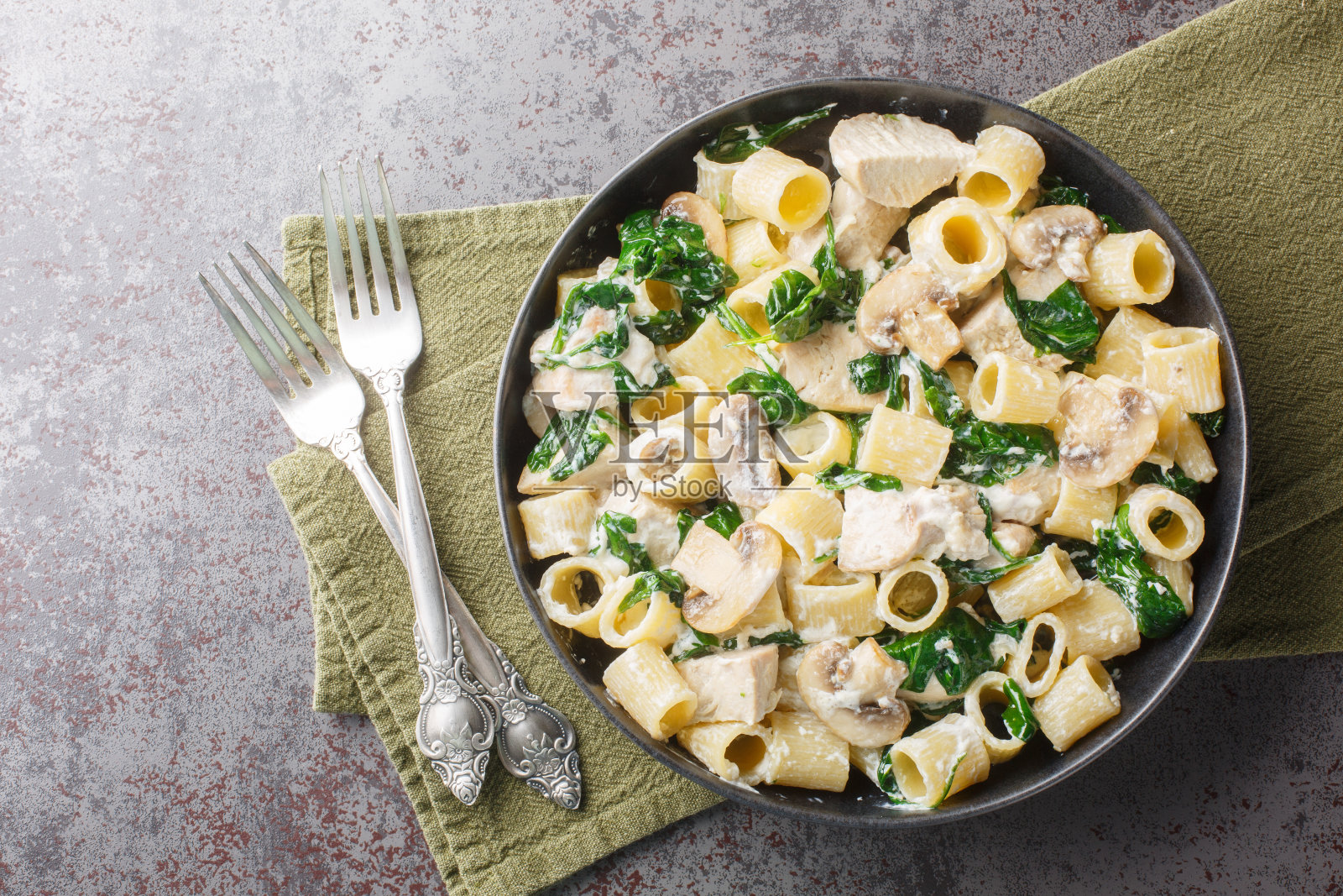 奶油意大利面配上鸡肉、炸蘑菇、大蒜、奶酪和菠菜。水平俯视图照片摄影图片