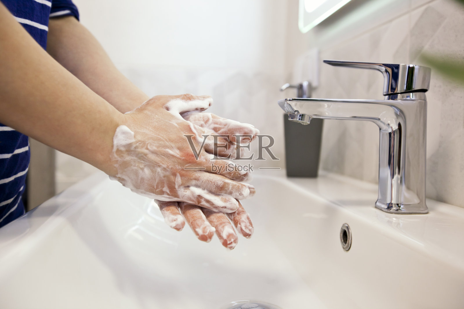 那个女人正在浴室里用肥皂洗手照片摄影图片