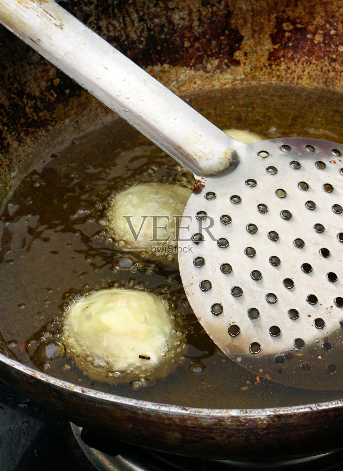 印度街头小吃摊贩用油锅煎点心照片摄影图片