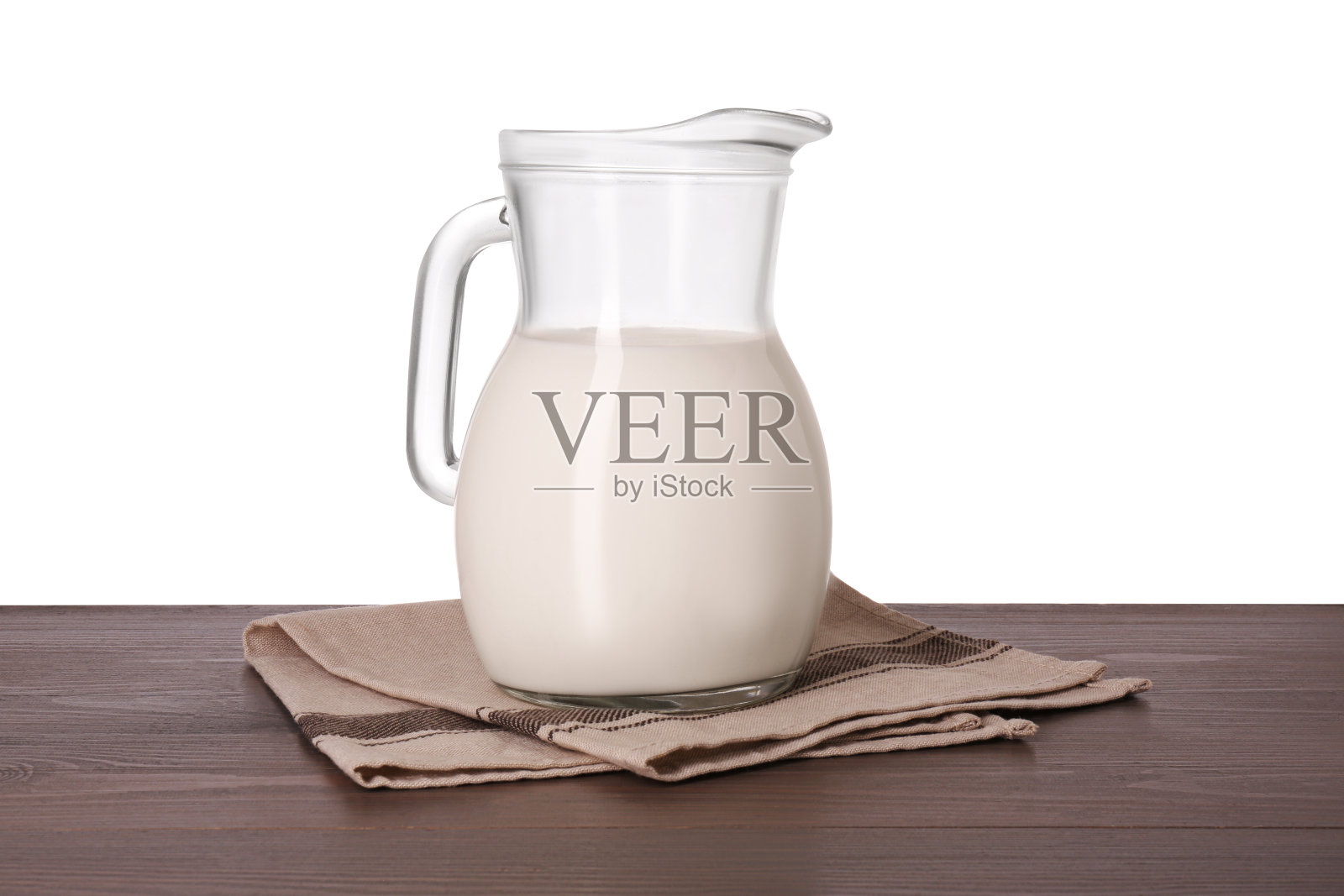 白色背景下木桌上的一壶可口的牛奶照片摄影图片