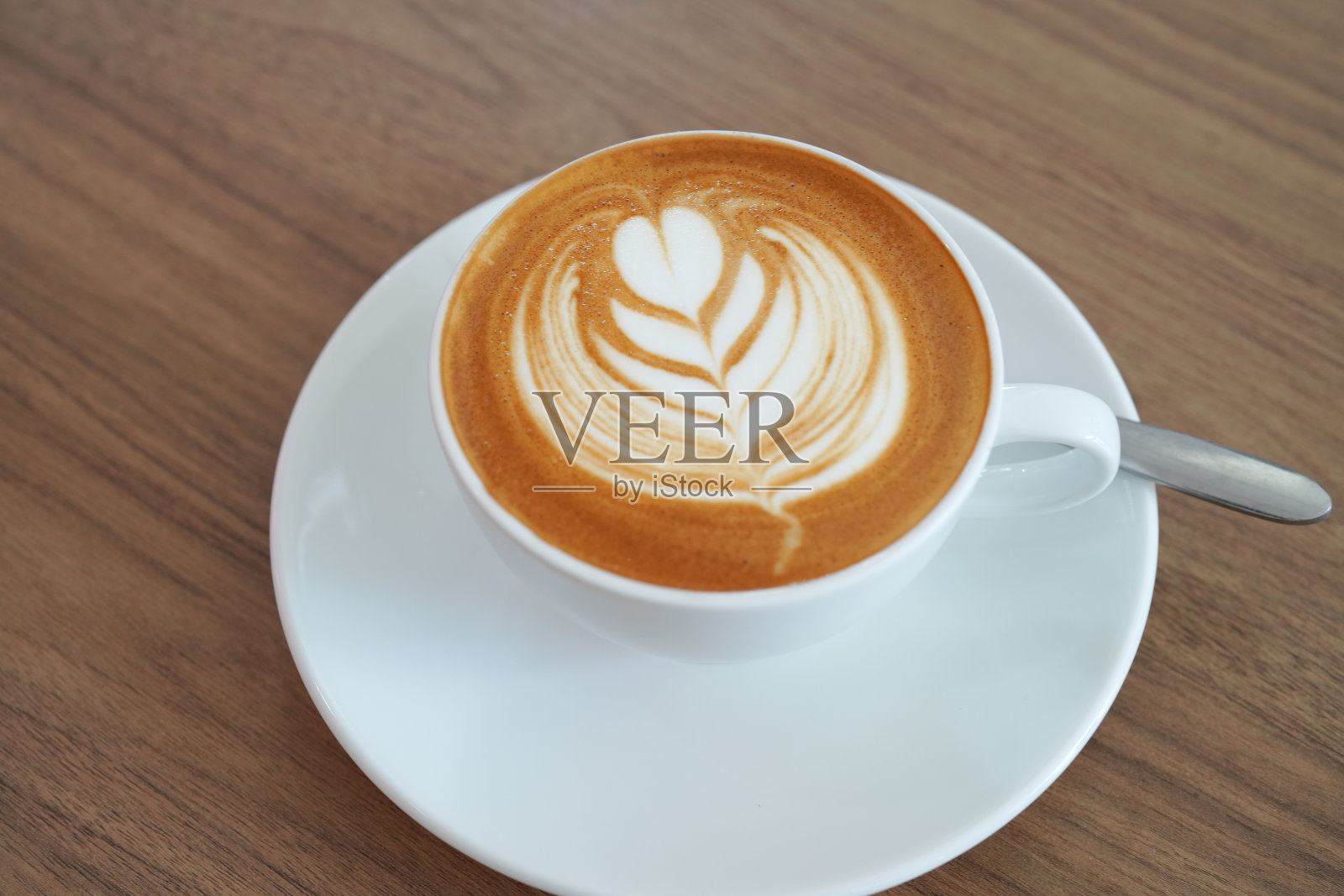 热拿铁咖啡与拿铁艺术在白色的杯子在白色的背景。副本的空间。照片摄影图片