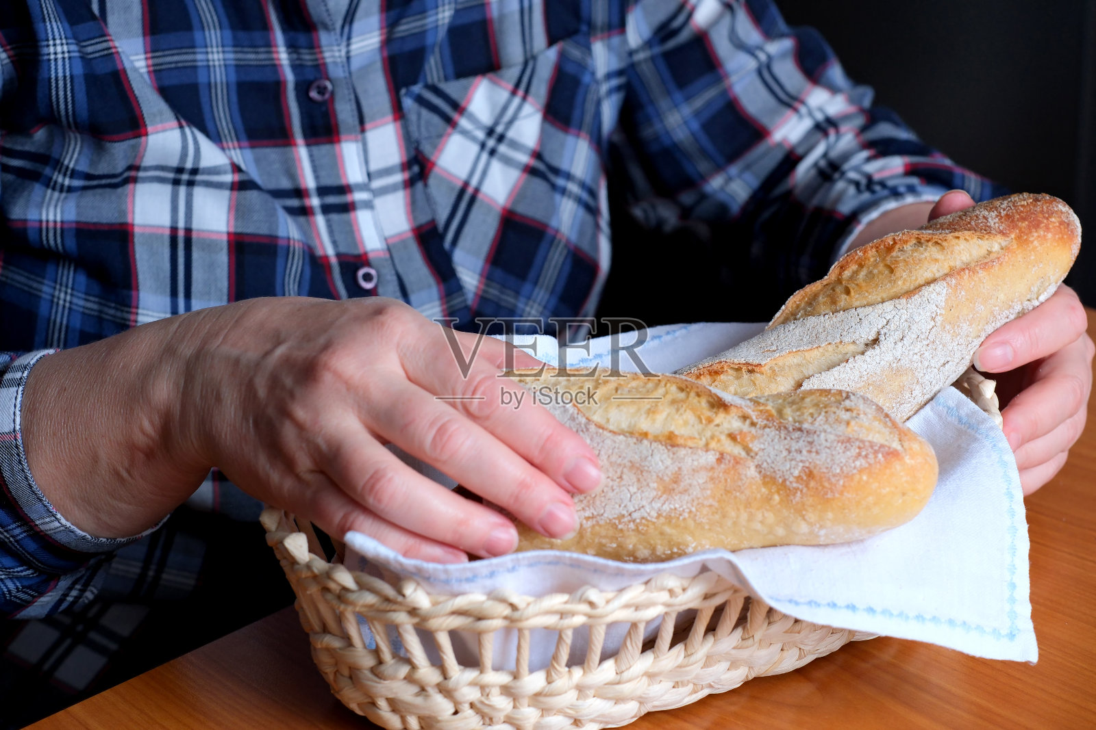 一位老妇人的手拿着切片的白小麦面包法棍照片摄影图片