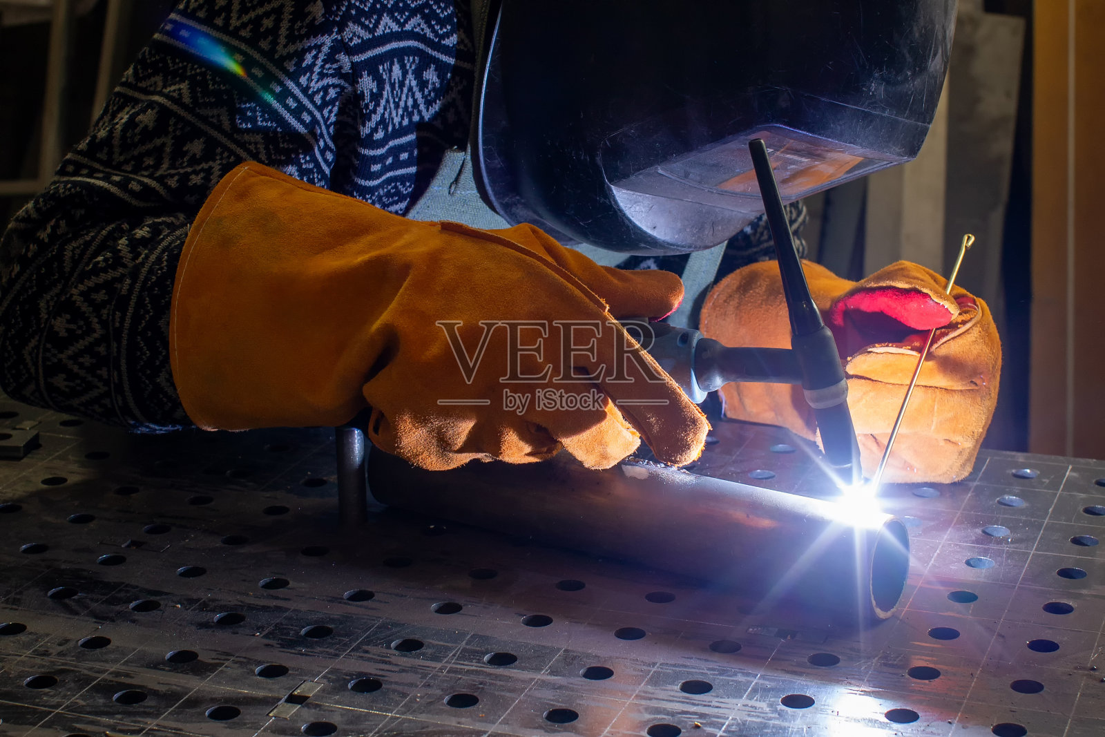 一位金属工匠在他的车间里工作。生产装饰金属元素。照片摄影图片