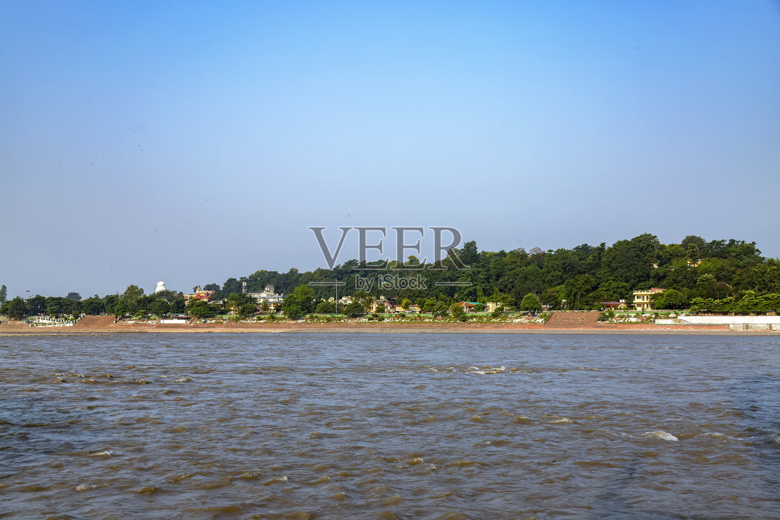 碧蓝多云的天空和郁郁葱葱的山峦映衬下，桥跨江面照片摄影图片