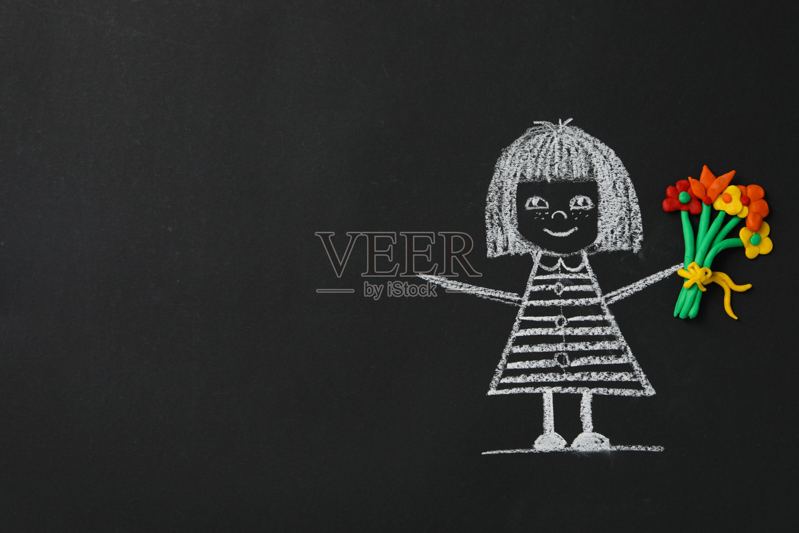 黑色的学校黑板上画着一个拿着花的女孩照片摄影图片