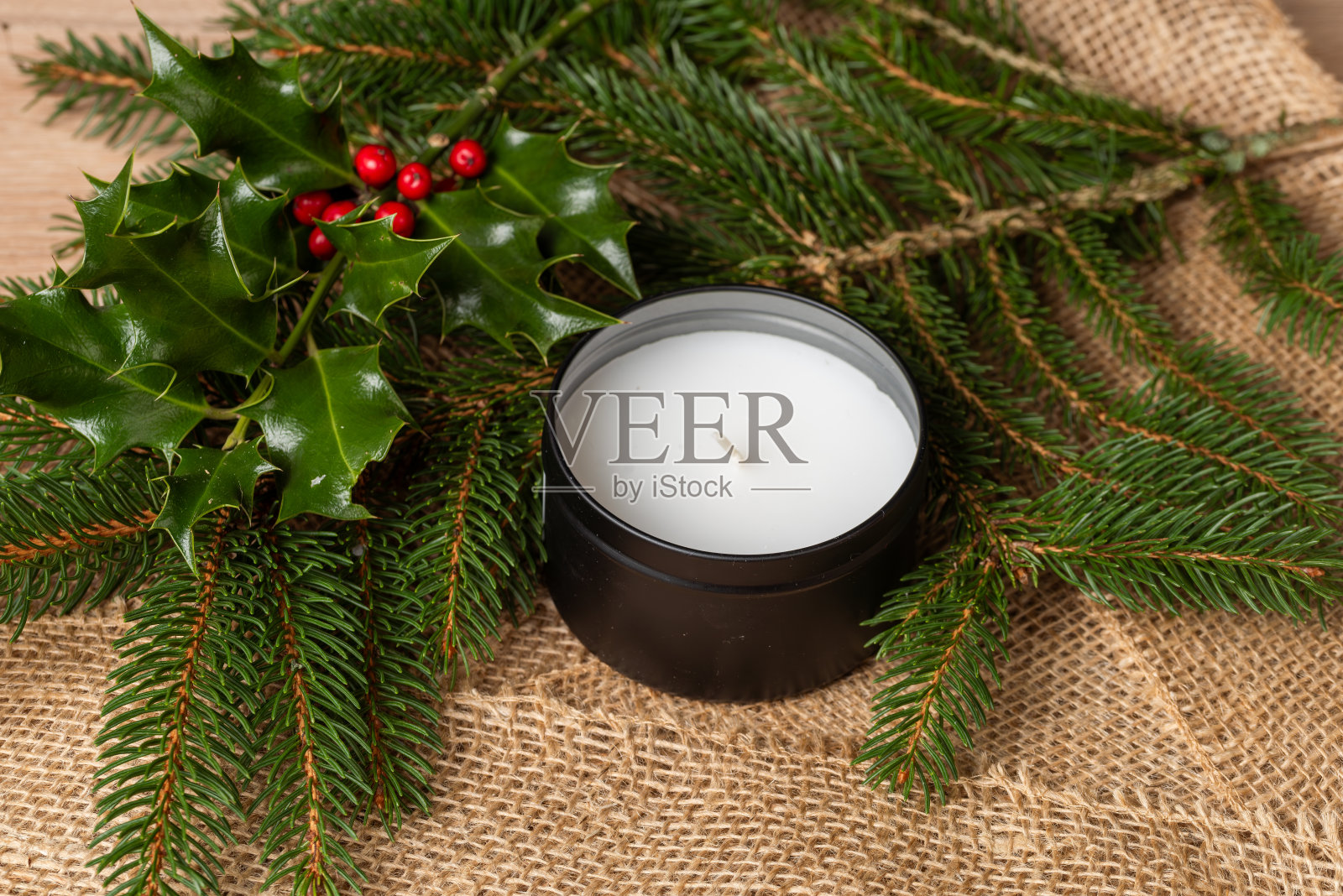 节日桌上的蜡烛。蜡烛立在冷杉树枝做成的圣诞花环上。圣诞节的背景照片摄影图片