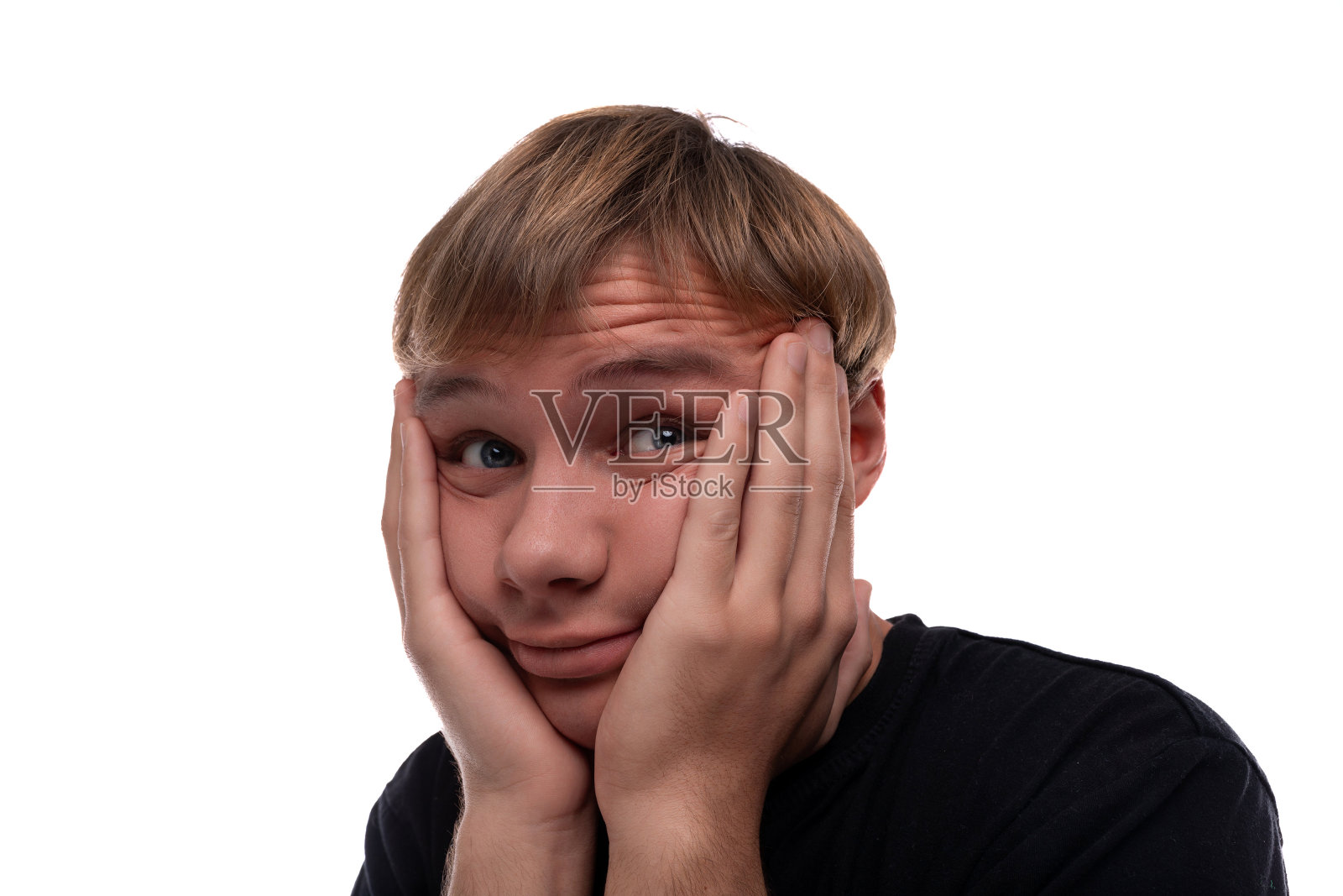 一个穿着黑色t恤的十几岁的男孩既兴奋又困惑照片摄影图片