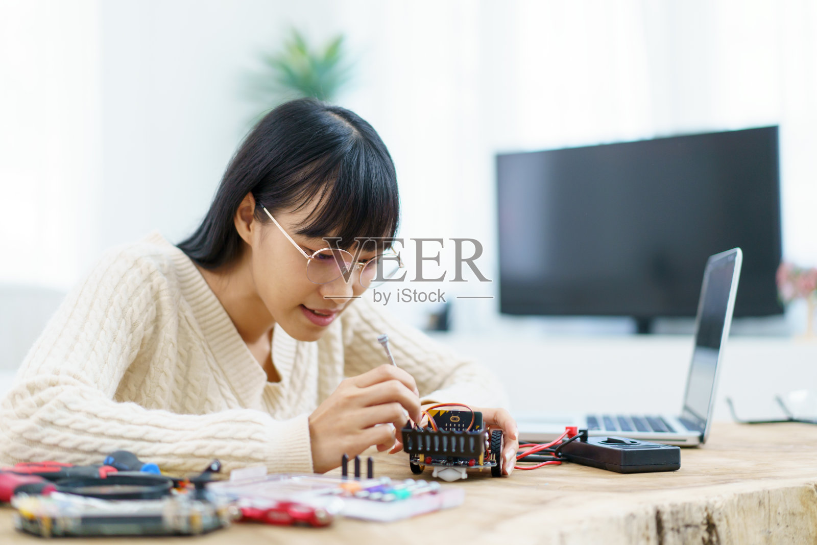 从事电子部件工作的亚洲妇女。照片摄影图片