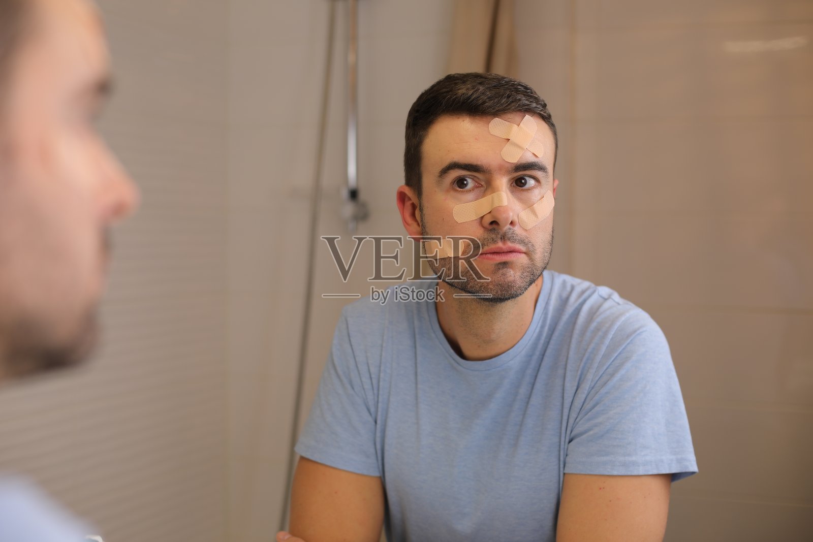 脸上贴满创可贴的人照片摄影图片