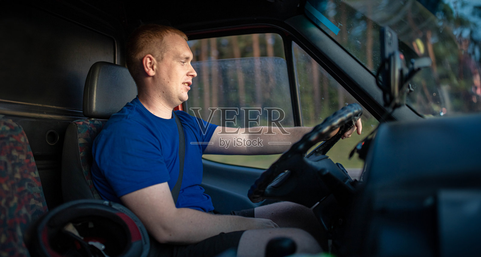 年轻的男性卡车司机在白天驾驶卡车。当司机照片摄影图片