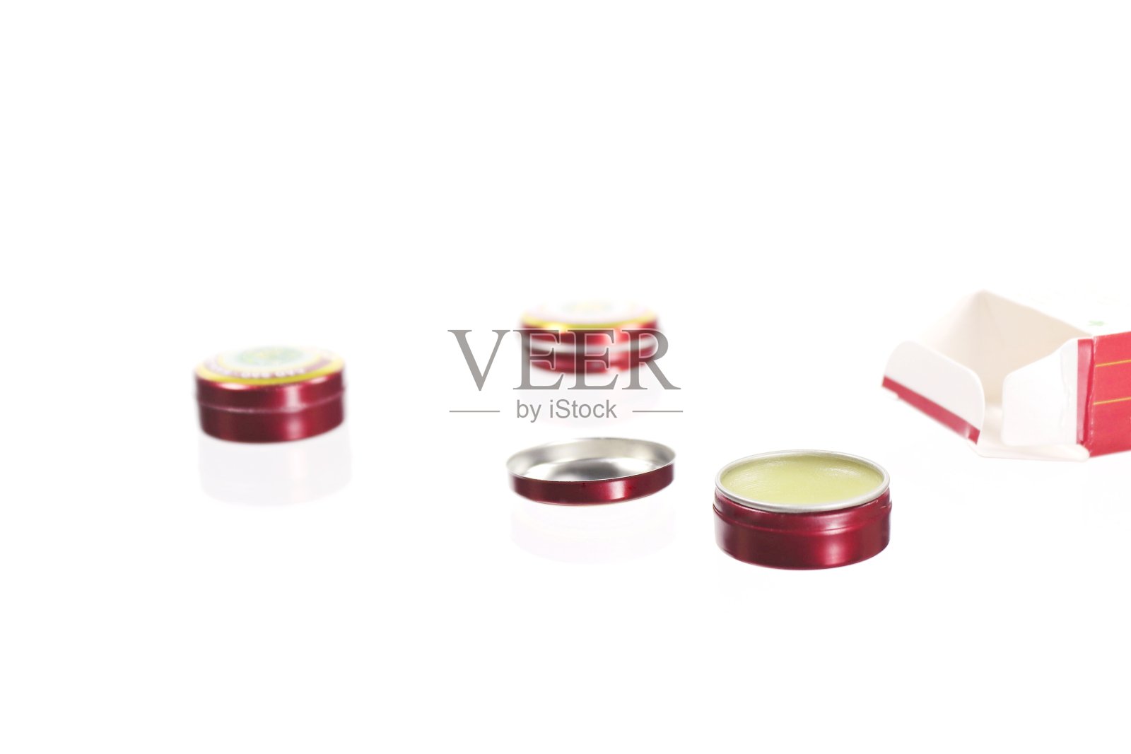 白底药膏的锡罐。照片摄影图片