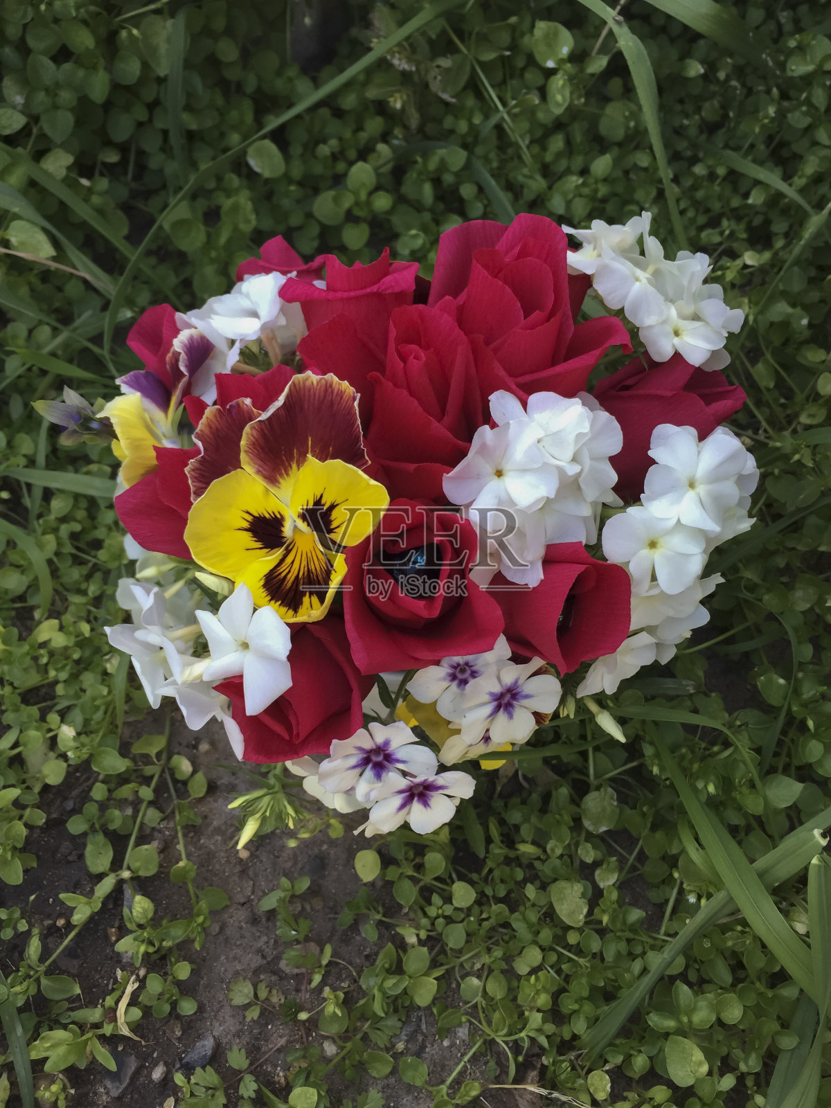绿草地上红黄三色堇的婚礼花束照片摄影图片
