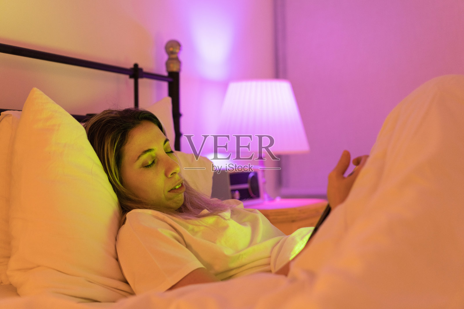 年轻女子看着电子平板电脑睡着了照片摄影图片