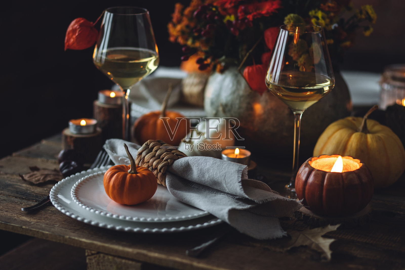 美丽的季节性装饰感恩节餐桌舒适的家庭晚餐或秋季豪华乡村婚礼。典雅美观，适合节日活动、聚会、招待会。酒杯和精美的菜肴。照片摄影图片