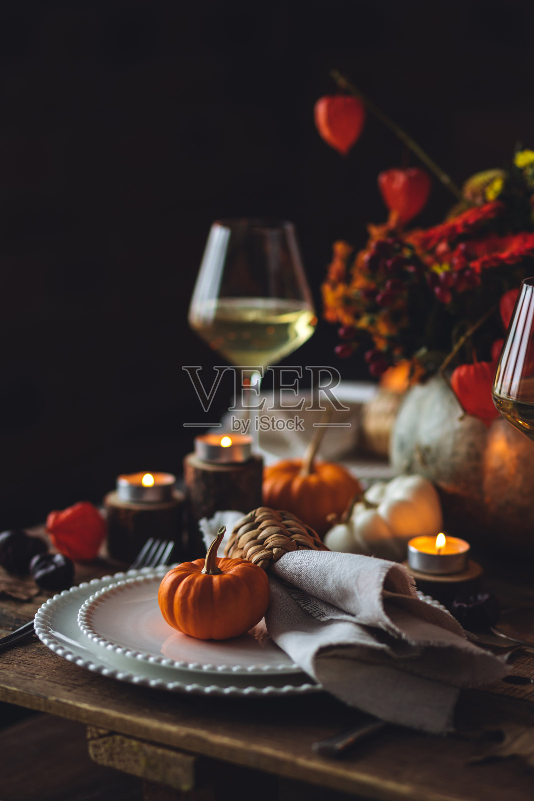 秋季餐桌装饰用南瓜、酒。家庭感恩节晚餐安排在户外花园。田园风格，简约的手工设置，秋天的心情照片摄影图片