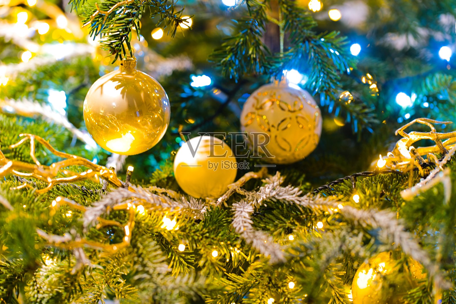 背景中闪烁的彩灯装饰着圣诞树。照片摄影图片