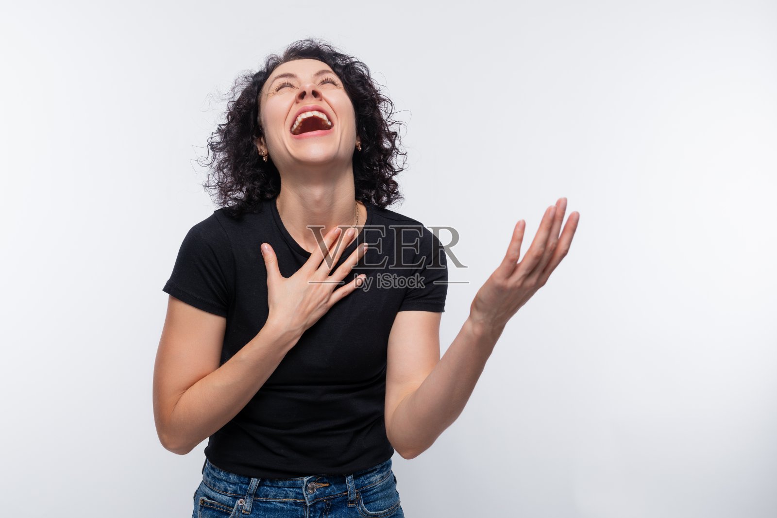 照片上是一个大声笑着的女人，一头烫发，穿着一件简单的t恤照片摄影图片