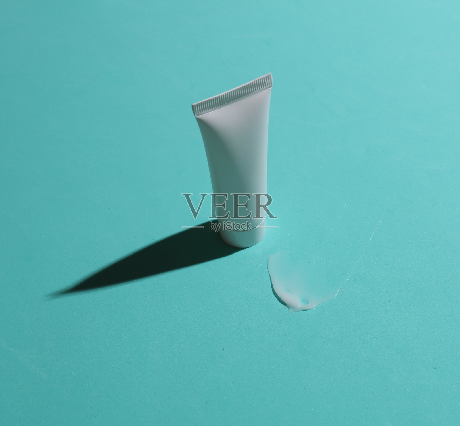 在蓝色背景上涂抹奶油的白色管的模型照片摄影图片