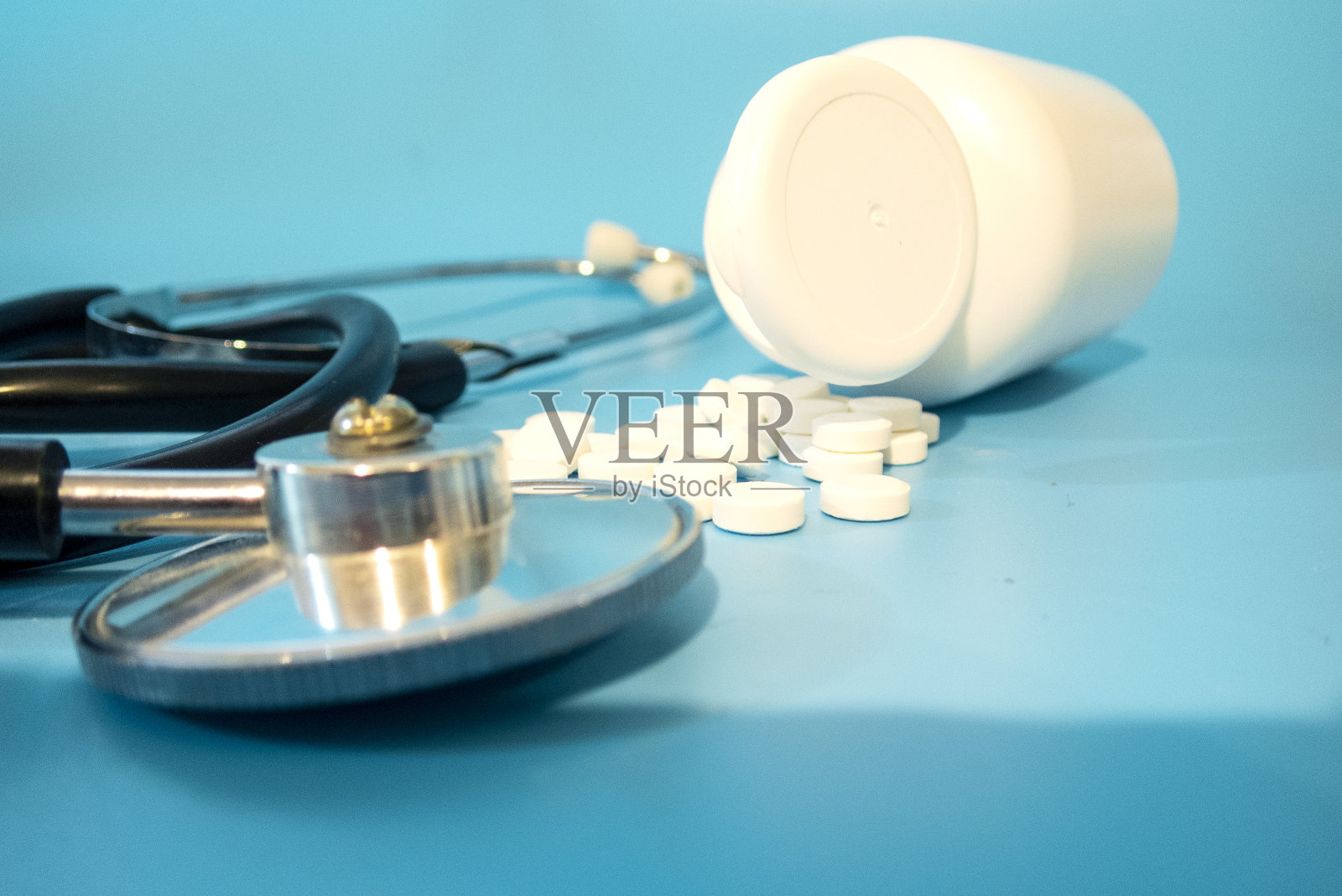 一个装有散落的白色药片的罐子和一个近距离的电话内窥镜。照片摄影图片