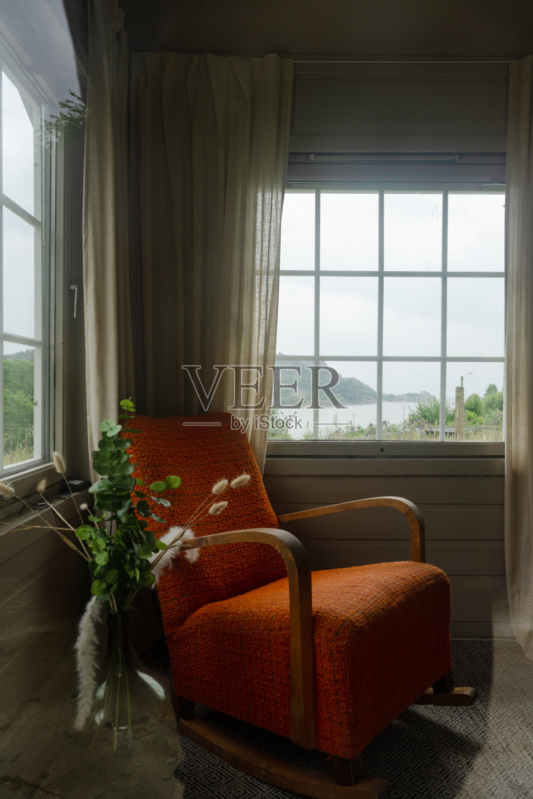 海边小房子里的老式橙色椅子。照片摄影图片