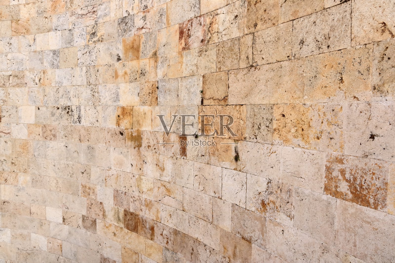 一种黄米色的天然石墙，大小不一的石头，传统工艺照片摄影图片