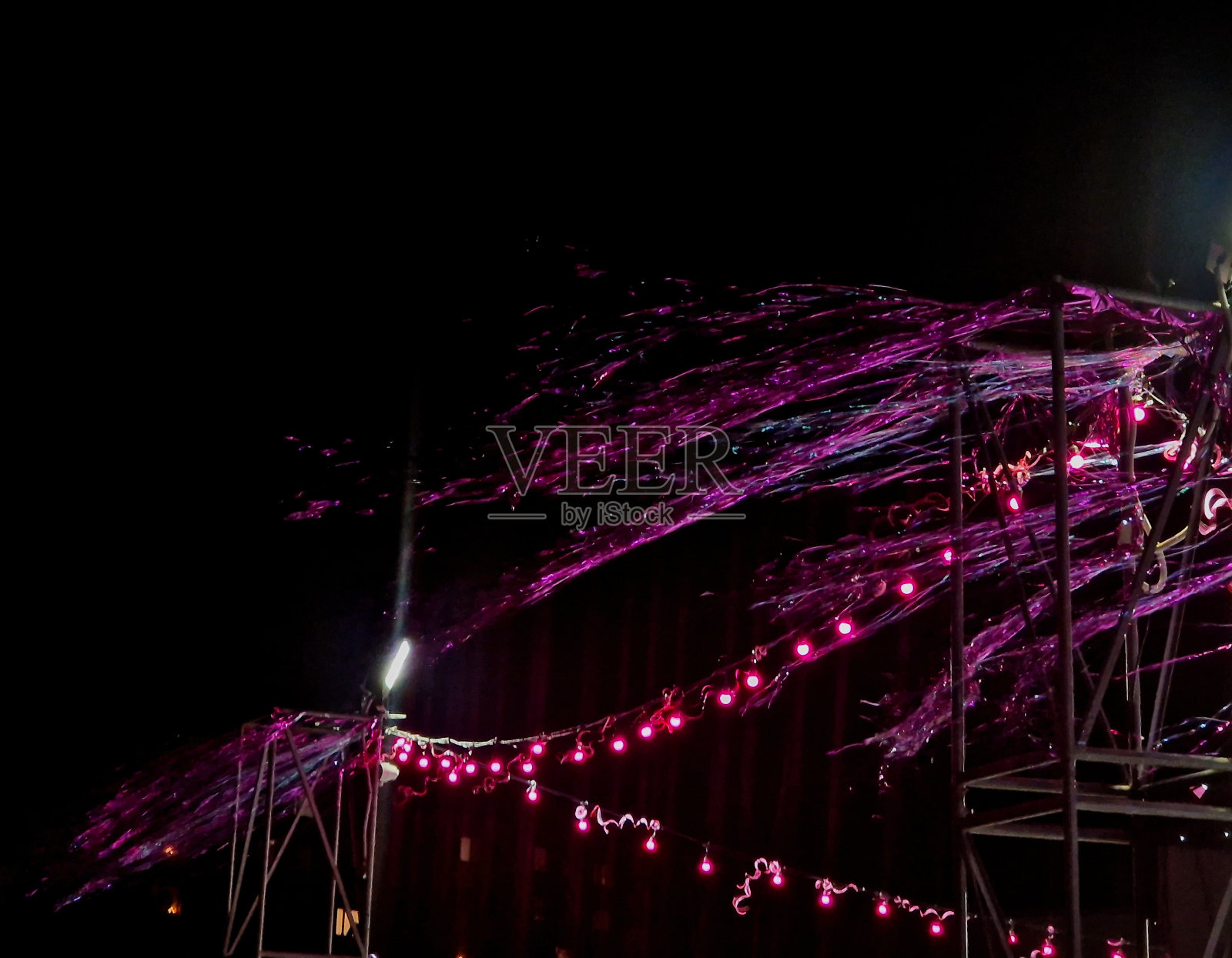 庆祝活动的装饰离不开链子上的许多灯。婚礼上有派对帐篷，晚上有很多灯泡在舞池里跳舞照片摄影图片