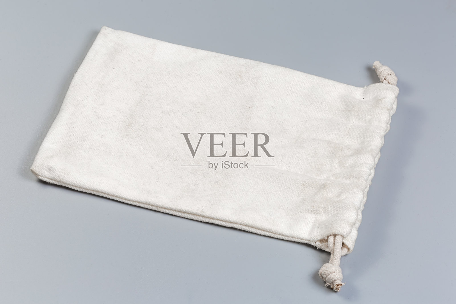 灰色背景上有绳封的白色空布袋照片摄影图片