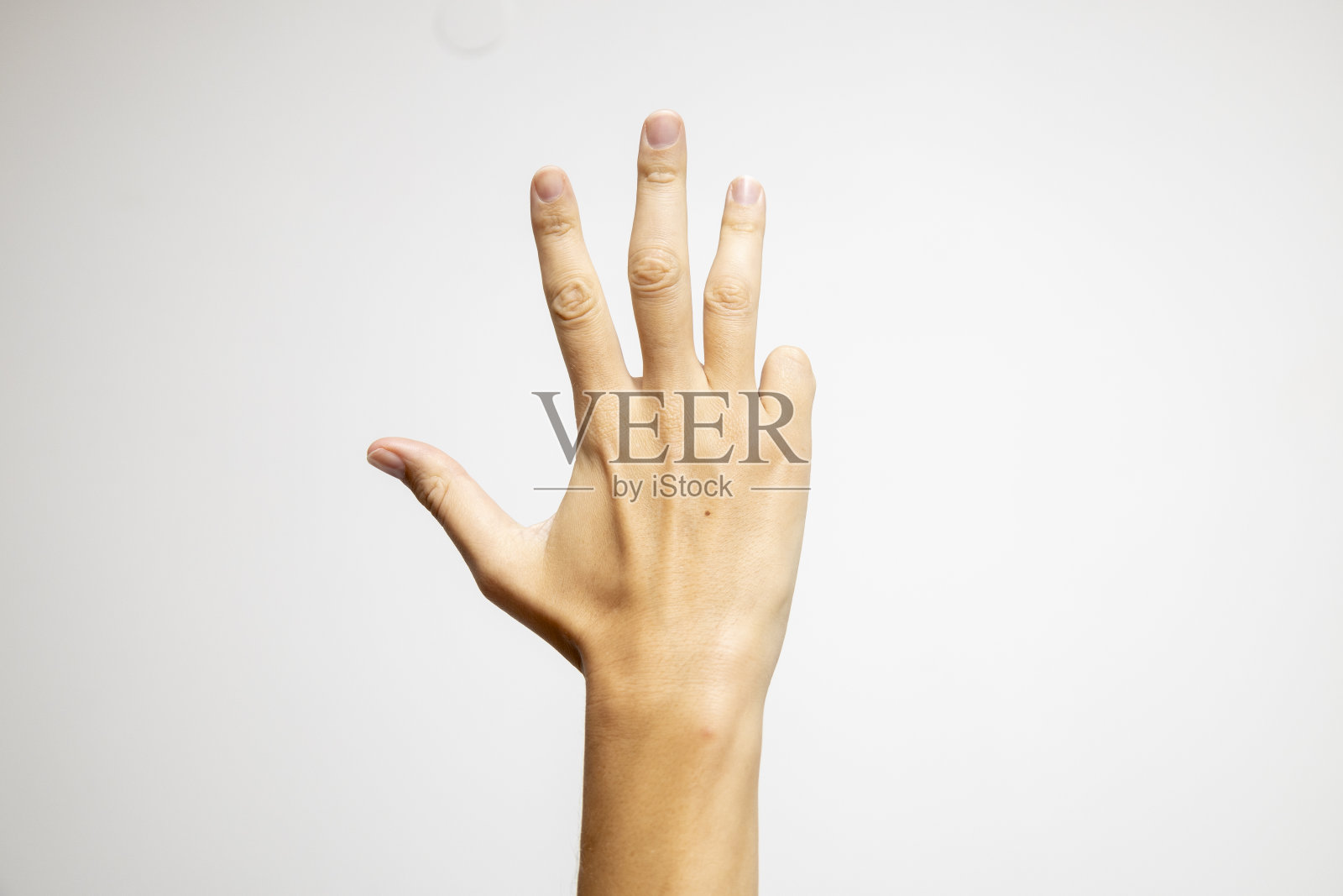 一只在白色背景上有四个手指的手。照片摄影图片