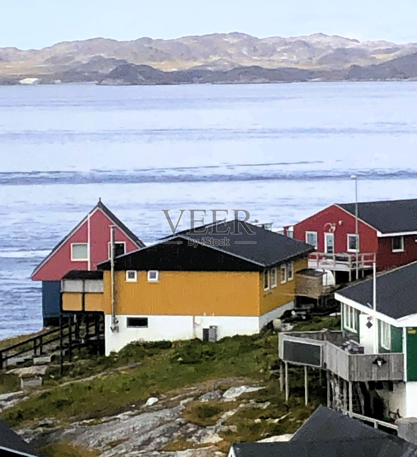 在格陵兰岛努克，以大海为背景，欣赏色彩缤纷的房屋照片摄影图片