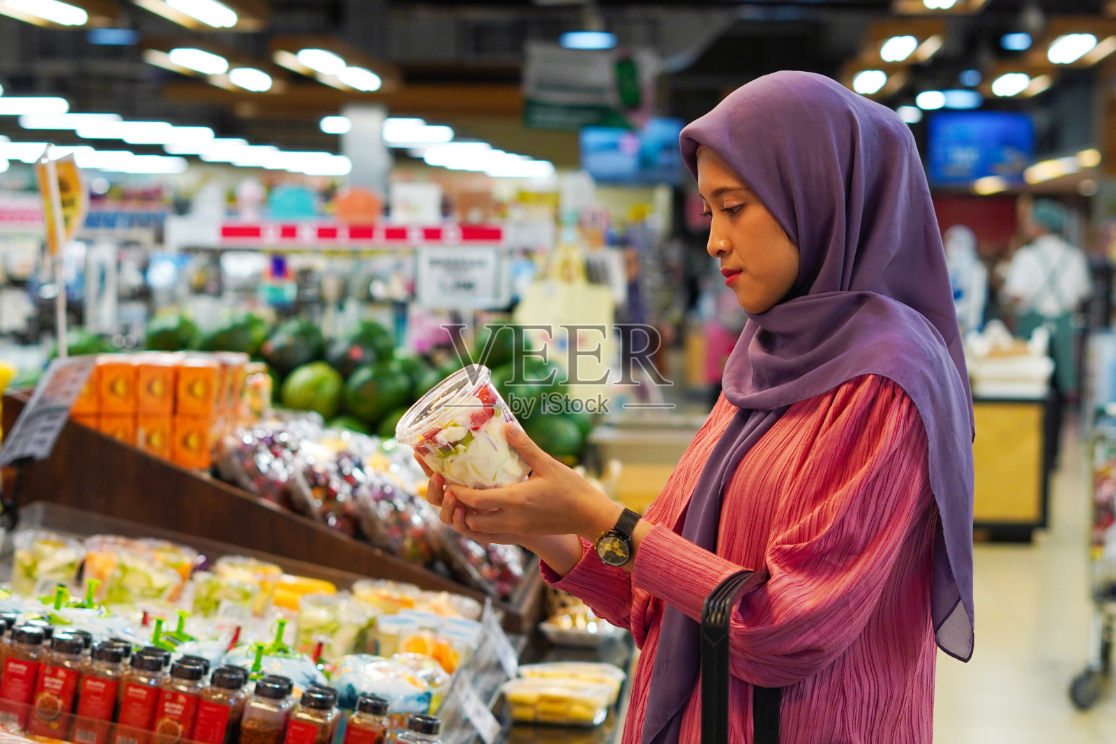 年轻的穆斯林妇女去杂货店。购物的概念照片摄影图片