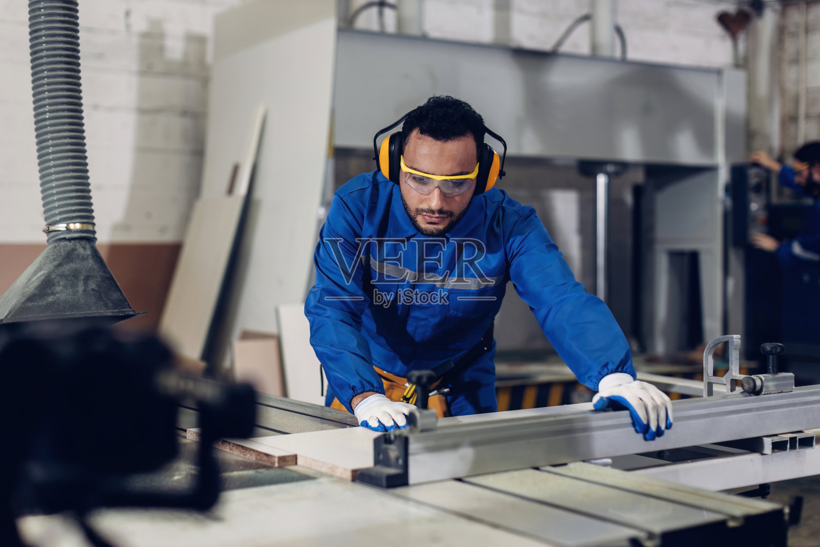 在木工车间使用木工机械制作木制家具的木匠照片摄影图片