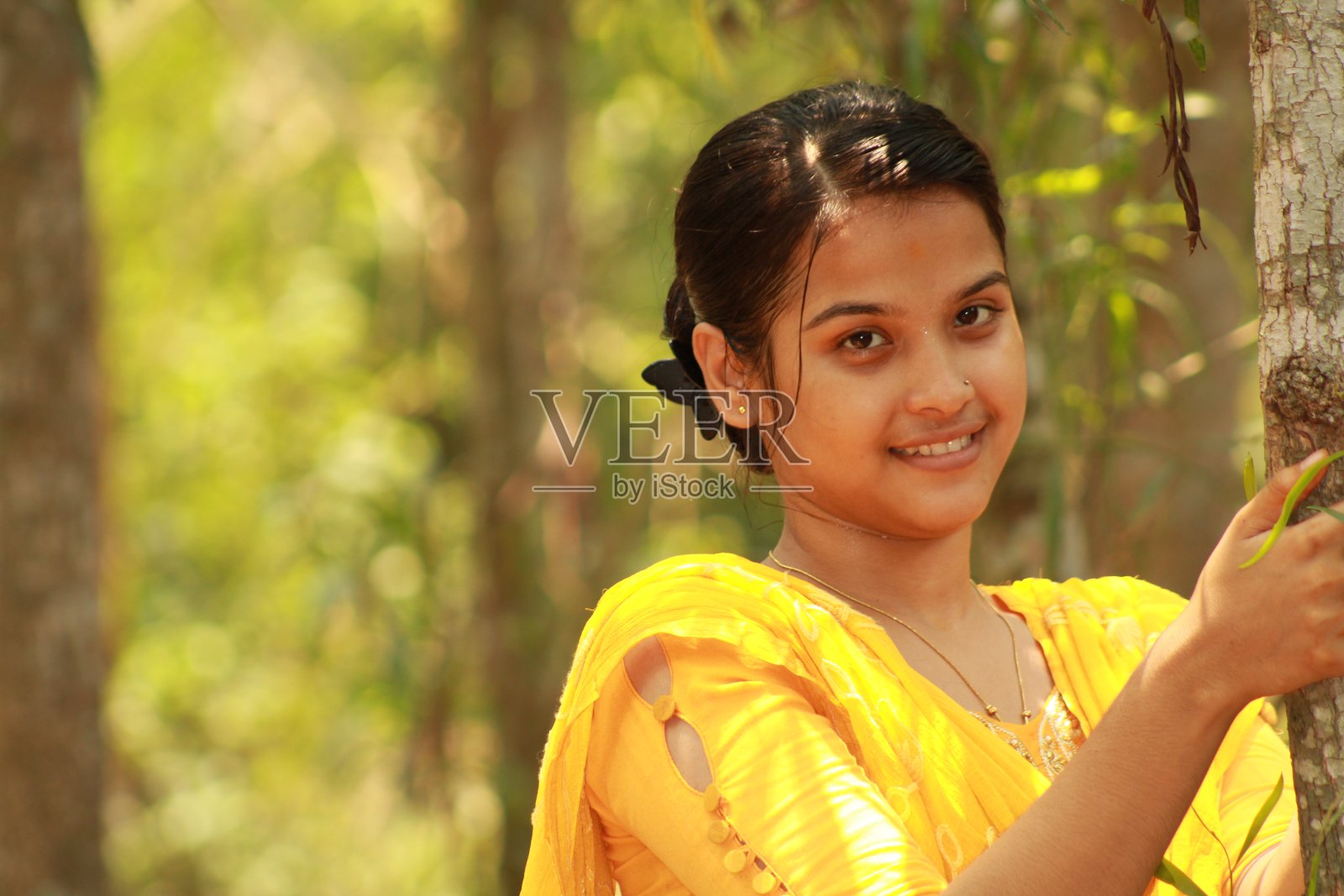 快乐的印度少女对着镜头露出露齿的微笑。照片摄影图片