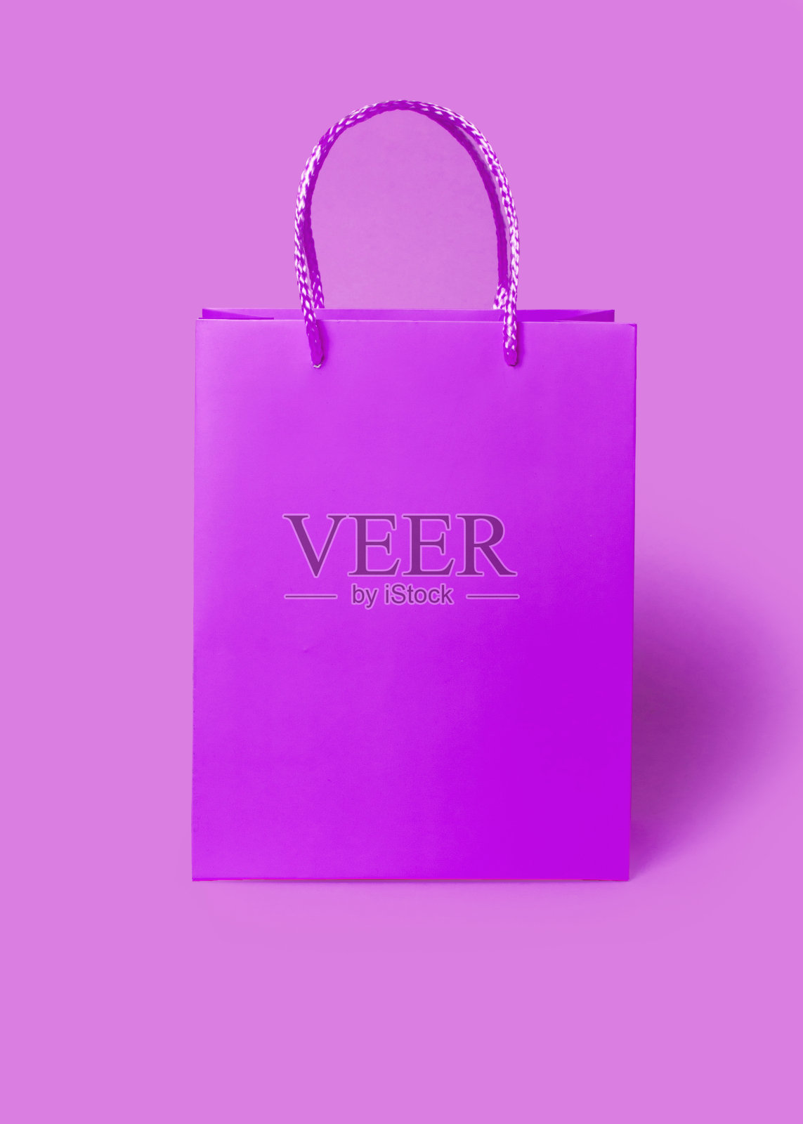 粉紫色纸购物袋粉紫色的背景。购物销售配送理念。包装礼物。照片摄影图片