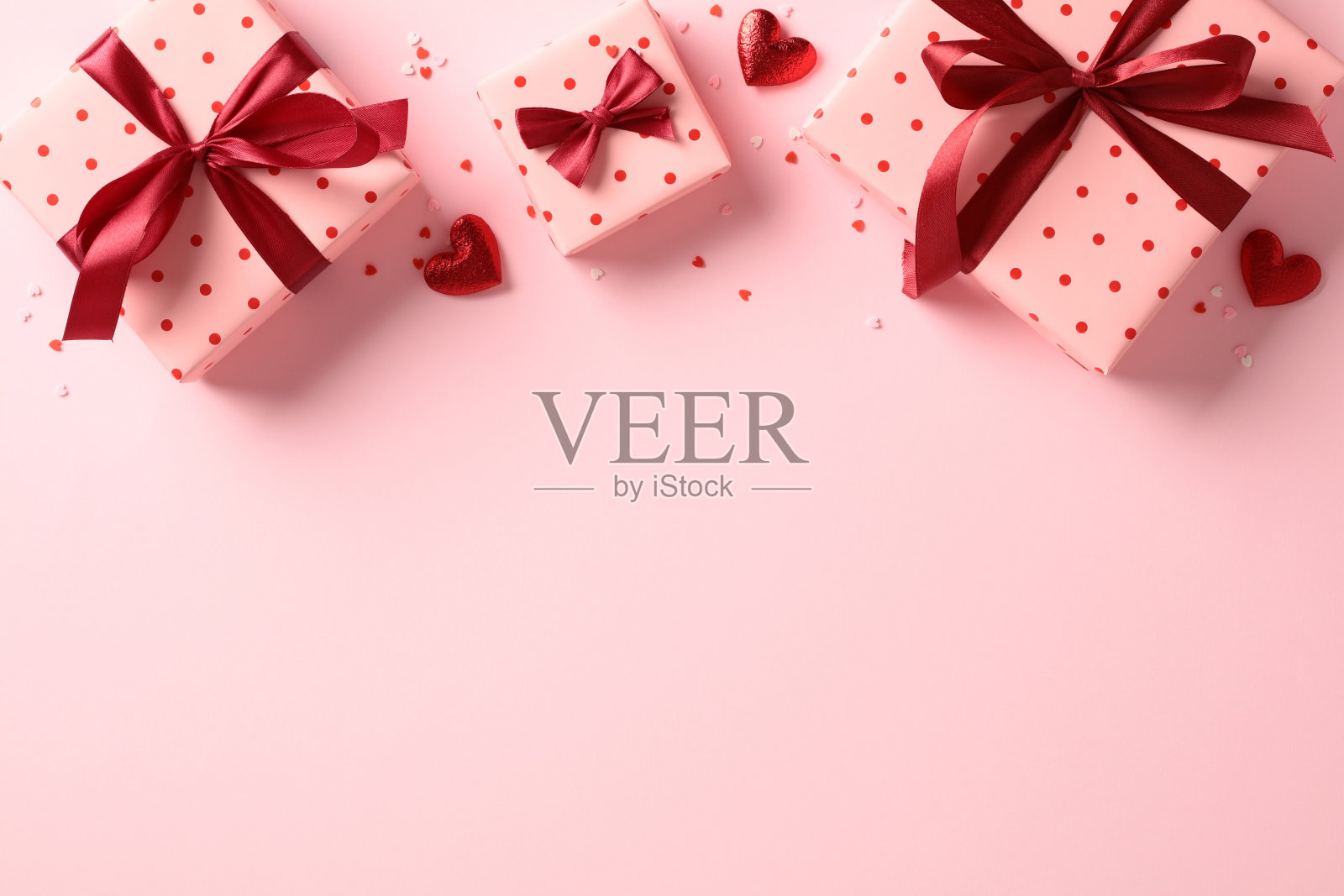 浪漫的情人节平面布局与礼盒和红色的心在粉红色的背景。照片摄影图片