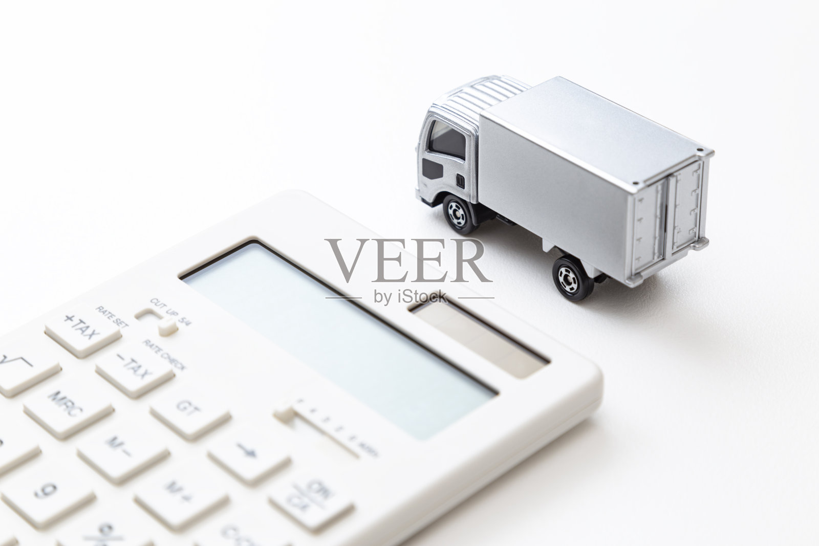 白色背景上的卡车和计算器。照片摄影图片