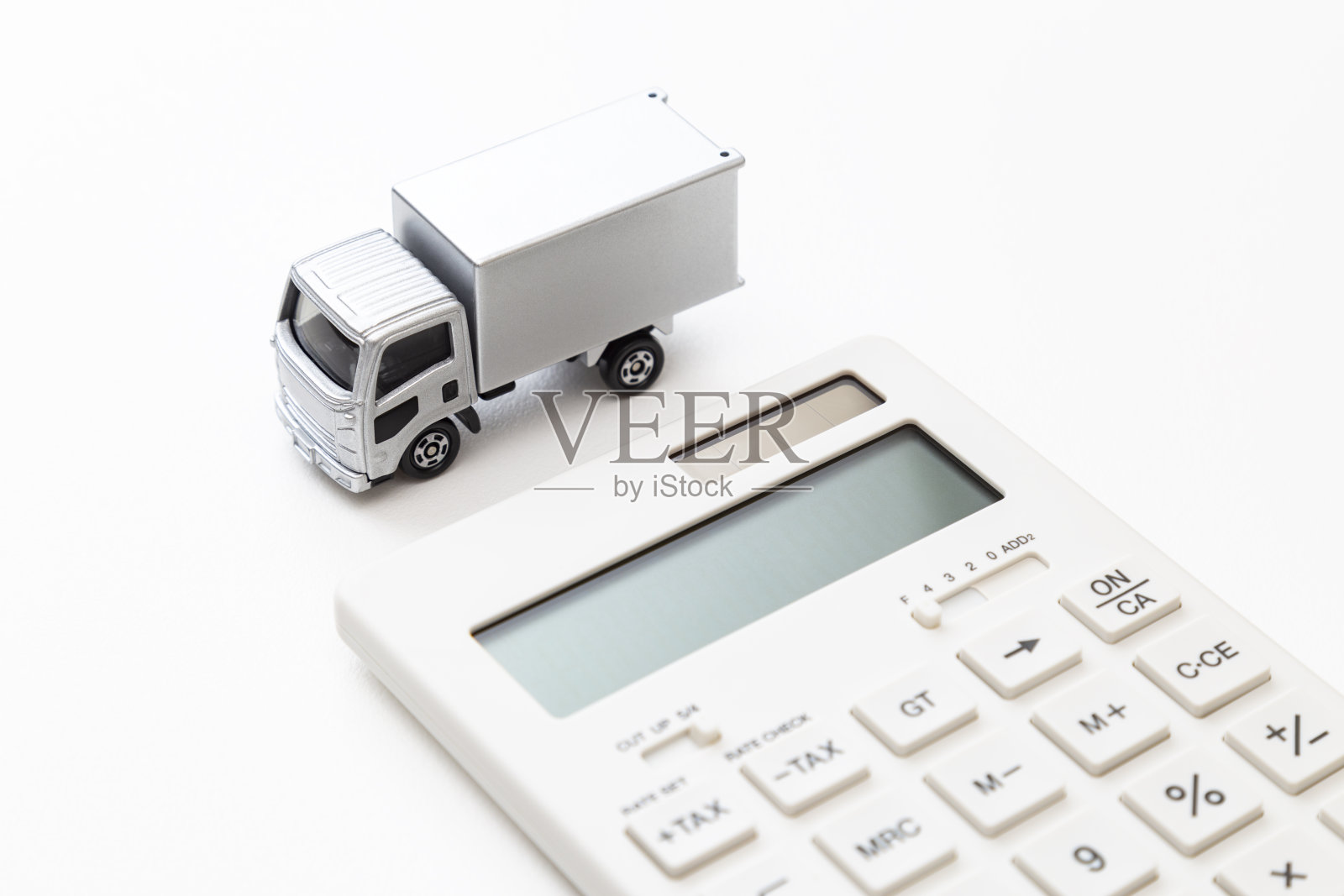 白色背景上的卡车和计算器。照片摄影图片