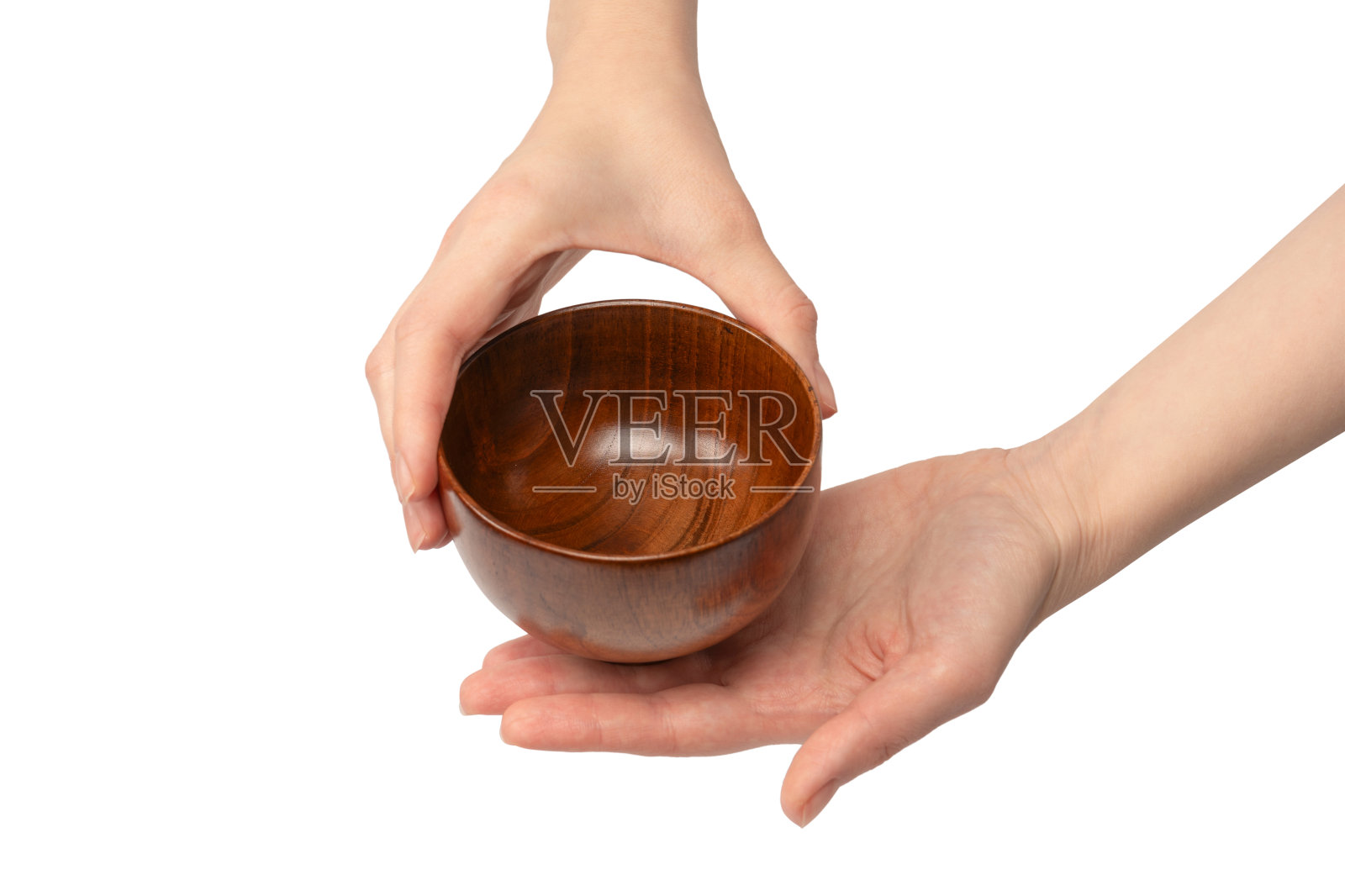 一个女人的手拿着一个木制的碗，孤立在白色的背景上。照片摄影图片