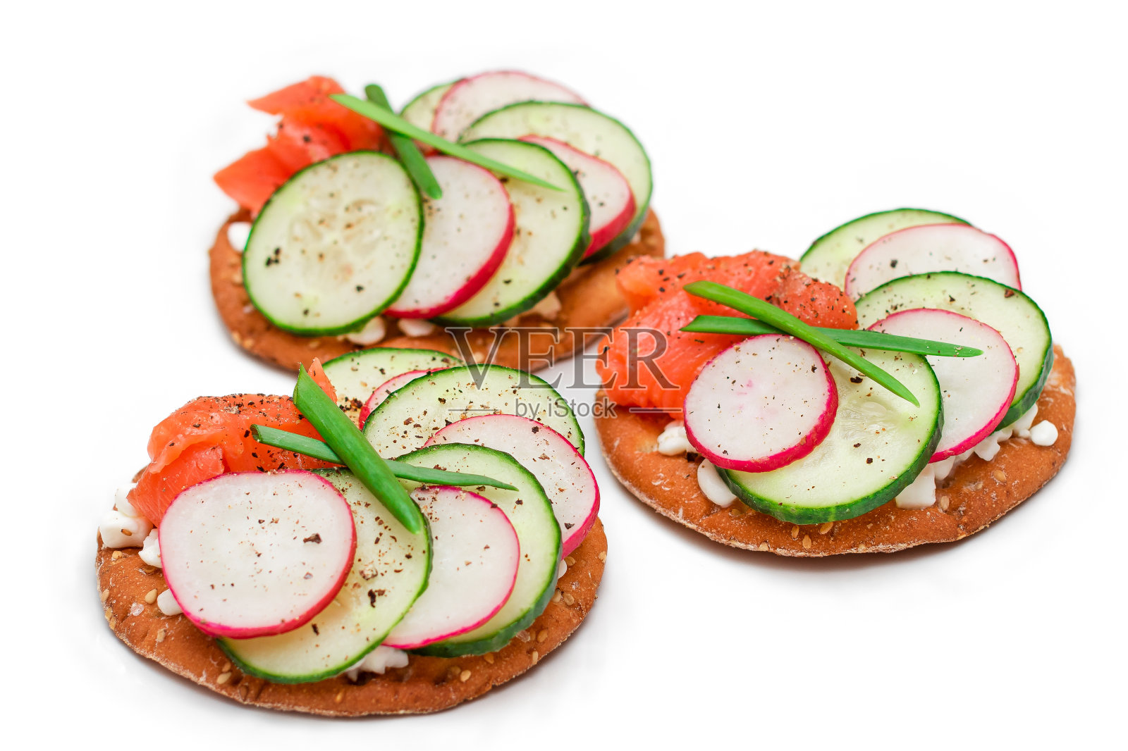 饼干三明治与鲑鱼，黄瓜，萝卜，白干酪和葱-分离照片摄影图片
