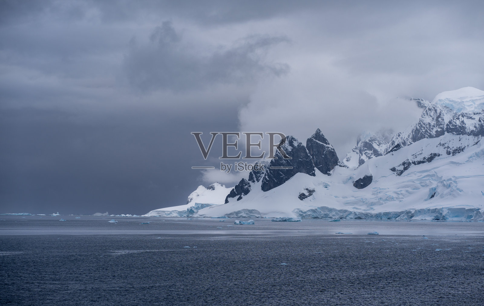 山脉和冰川从海中升起，进入雾中照片摄影图片