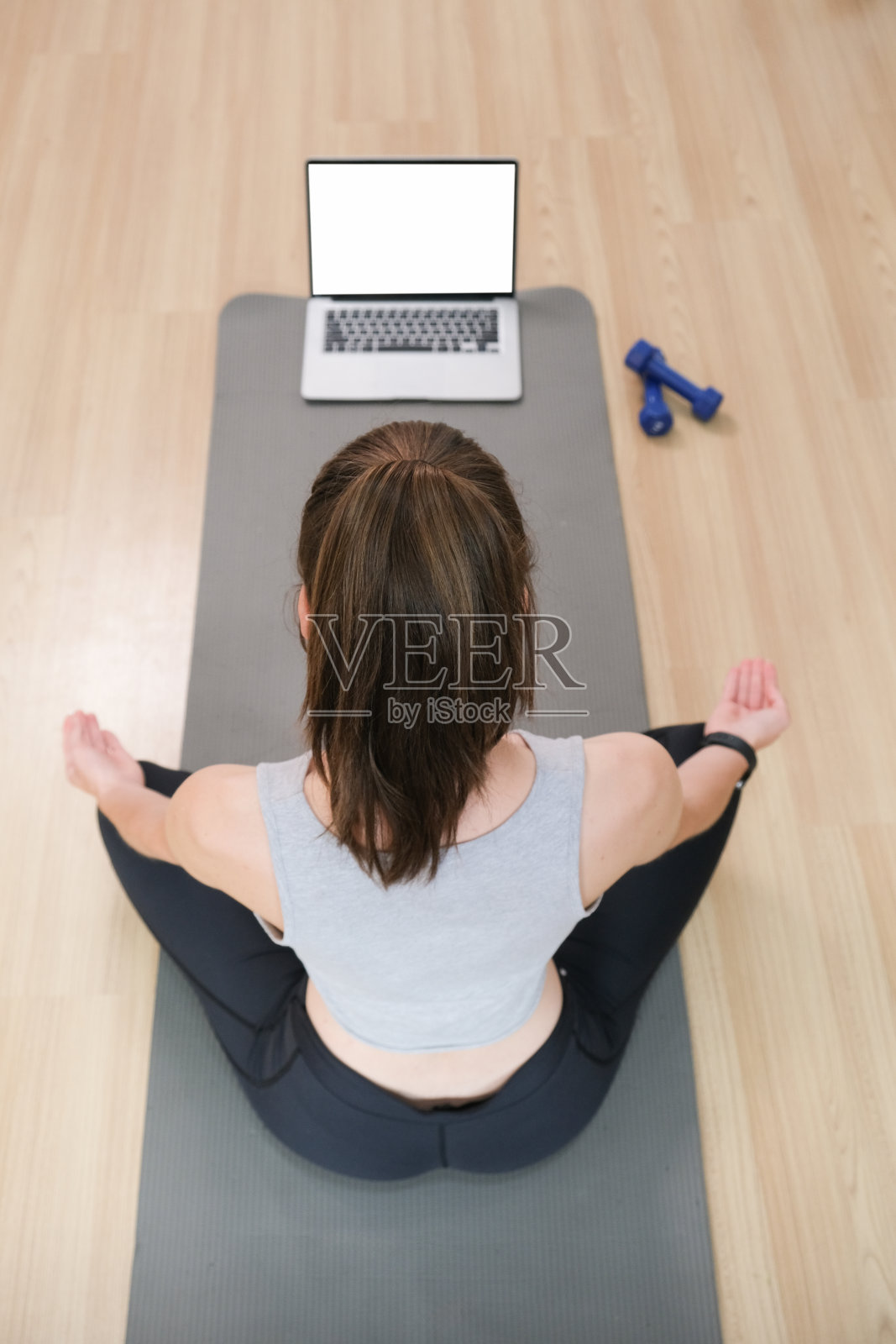 在家锻炼。有魅力的女孩在家锻炼，在笔记本电脑上看视频教程。照片摄影图片