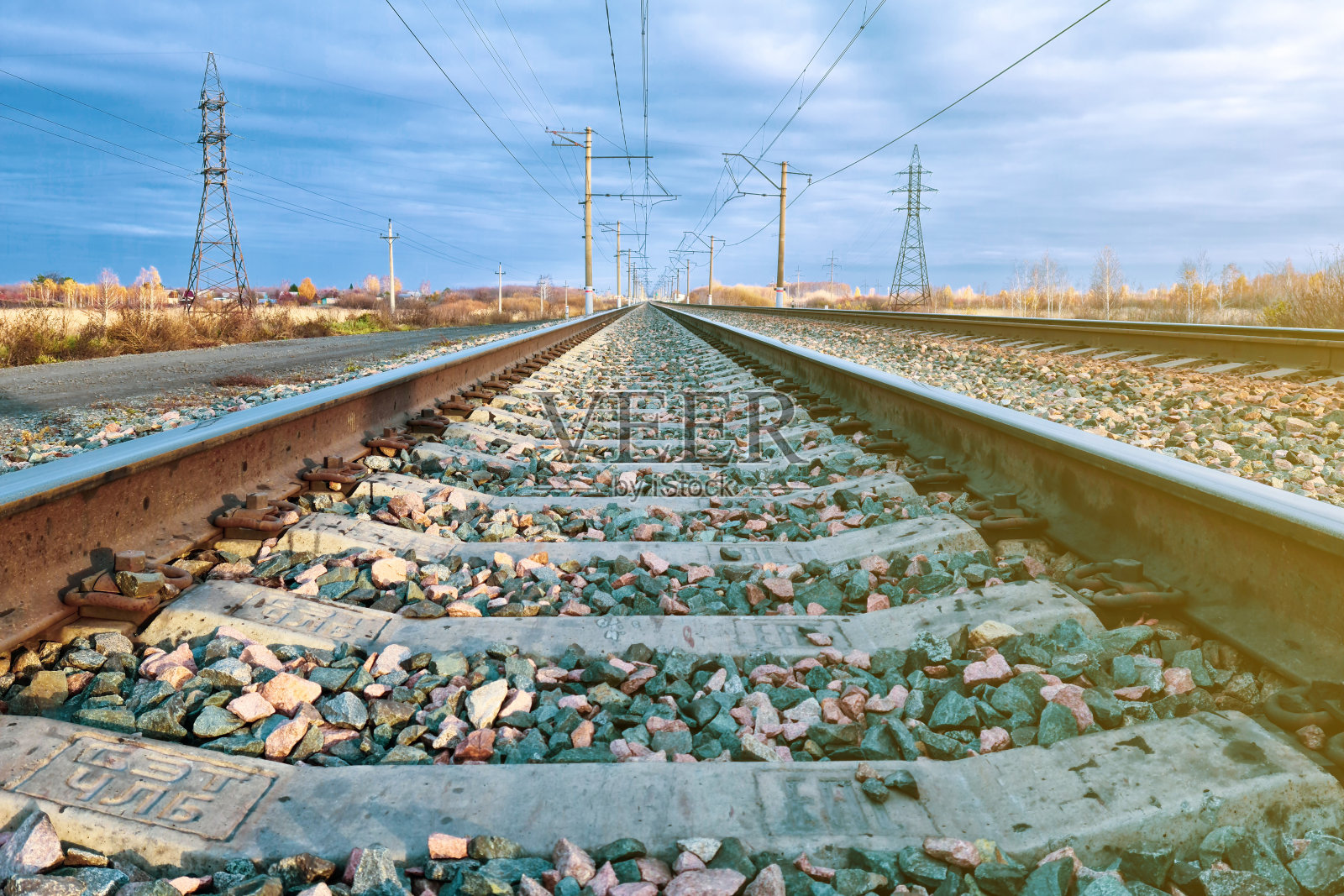 铁路，铁轨和枕木在暴风雨的天空下日落的特写照片摄影图片