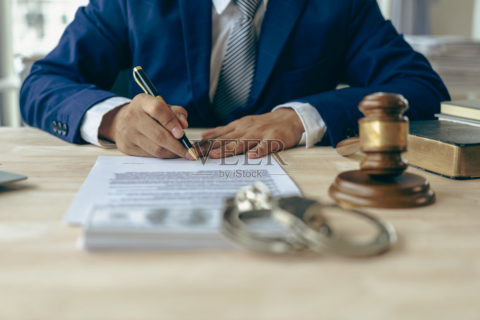 律师拿着合同文件和锤子工作的特写镜头，在正义的天平上，法律顾问的概念。照片摄影图片