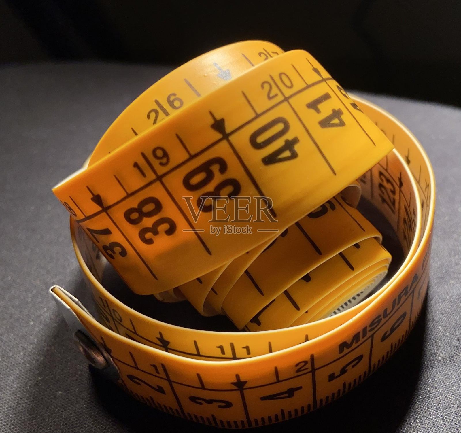 厘米塑料条裁缝和时装车间。用于国内和专业缝纫项目的卷尺。中性和浅色或深色背景。照片摄影图片